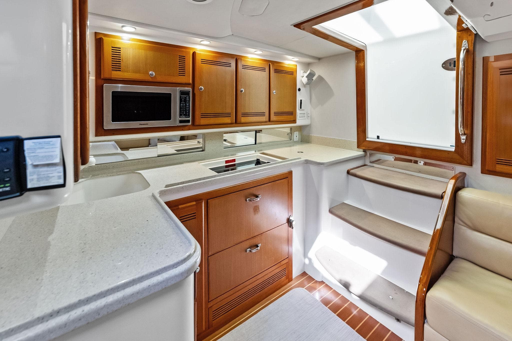 Luxurious 2006 Cabo 45 Express yacht interior with modern kitchen and wooden cabinetry.