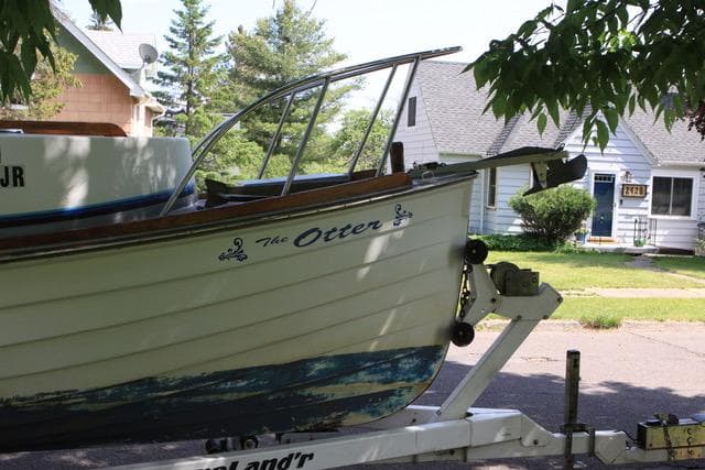 1990 Grover Verity Skiff boat named "The Otter" on a trailer in a suburban neighborhood.
