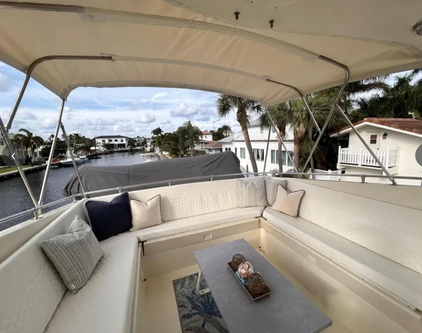 Spacious seating area on 1989 Hatteras 67 Cockpit Motor Yacht, overlooking a scenic waterfront.