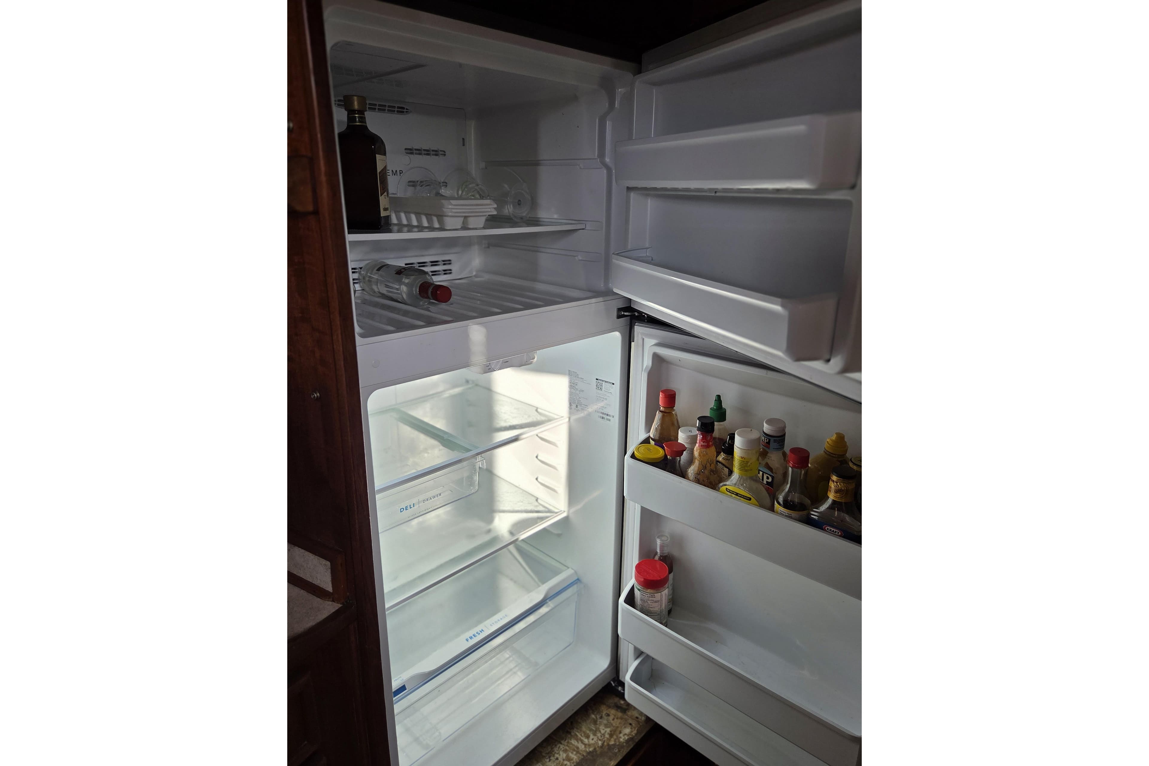 Open refrigerator in 1981 Uniflite MY, stocked with condiments and beverages.