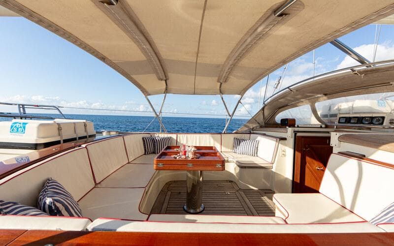 Luxurious 1996 Royal Huisman Custom yacht interior with elegant seating and ocean view.