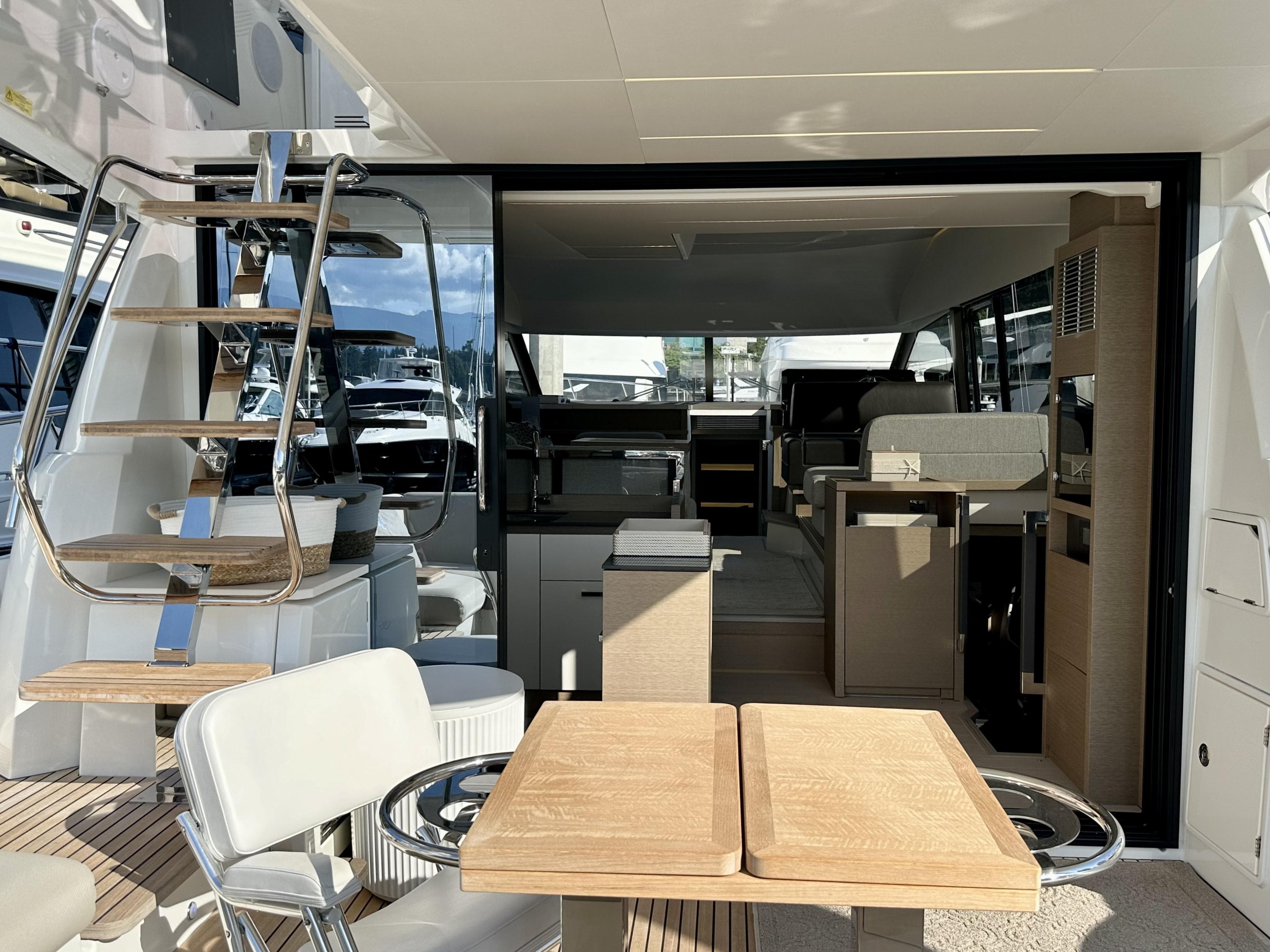 Luxurious 2023 Prestige 520 yacht interior with modern seating and elegant wooden table.