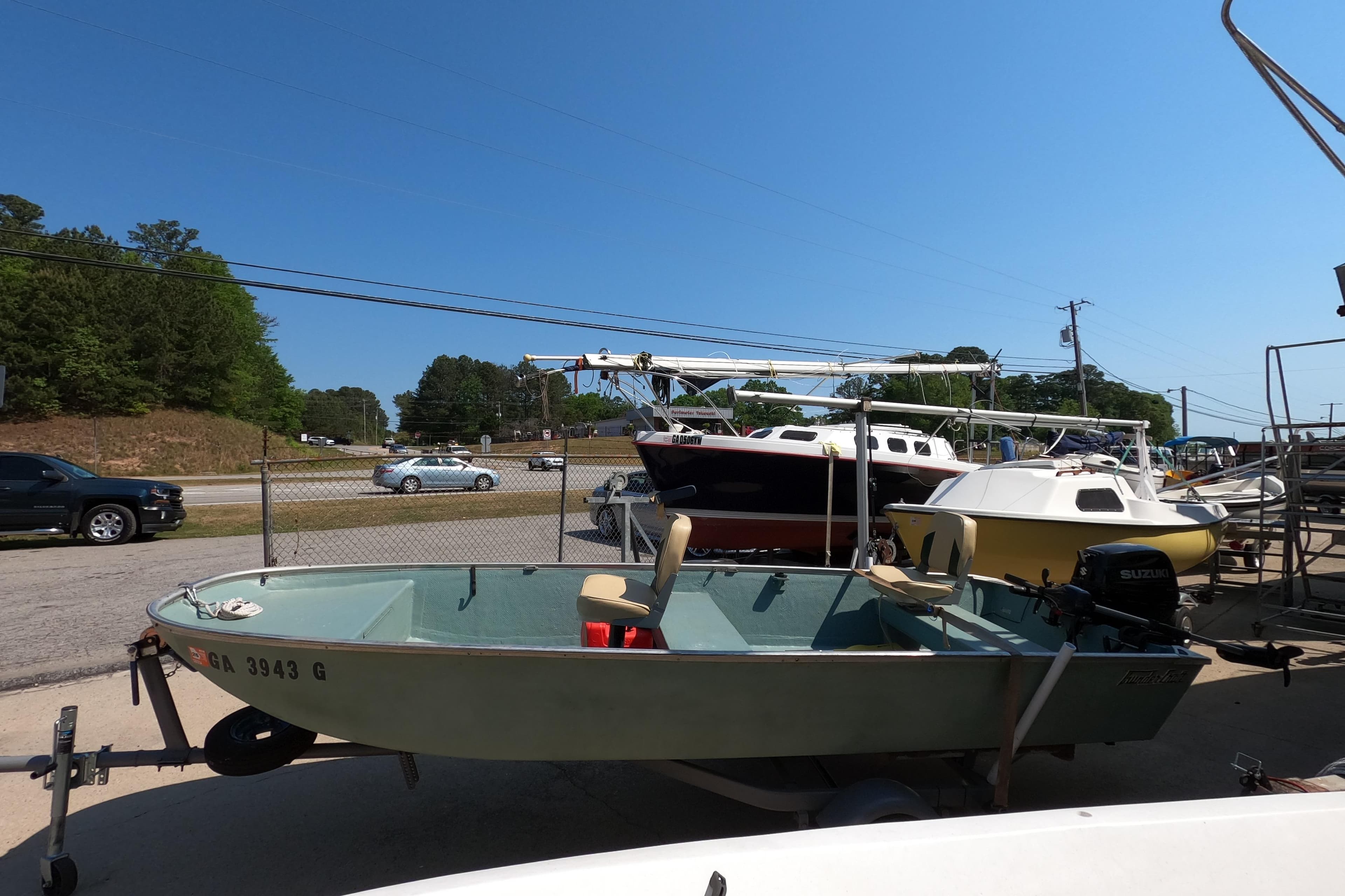 1969 Thundercraft 14 boat on trailer, parked outdoors under clear blue sky.
