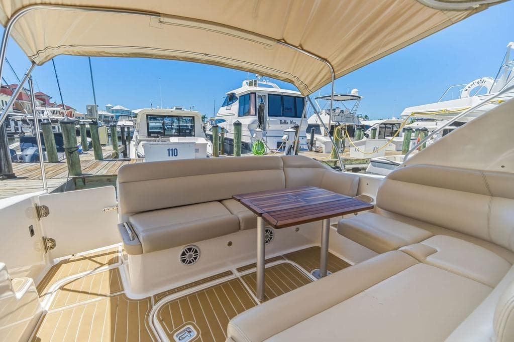 2008 Tiara Yachts 3900 Sovran interior with beige seating and wooden table at marina.