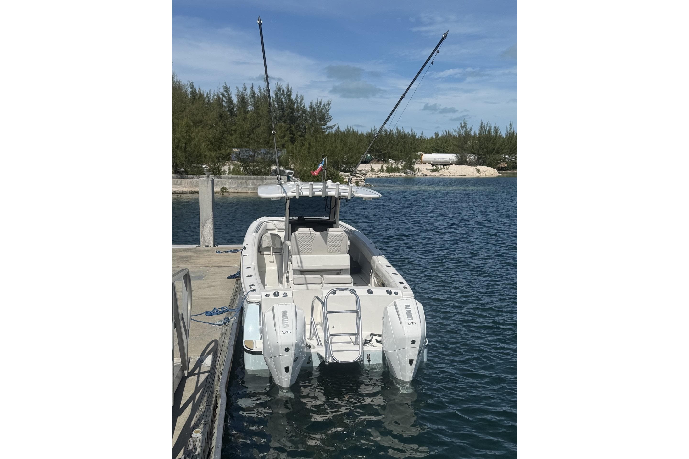 2025 World Cat 280 CC-X boat docked, featuring dual outboard engines and fishing rods.