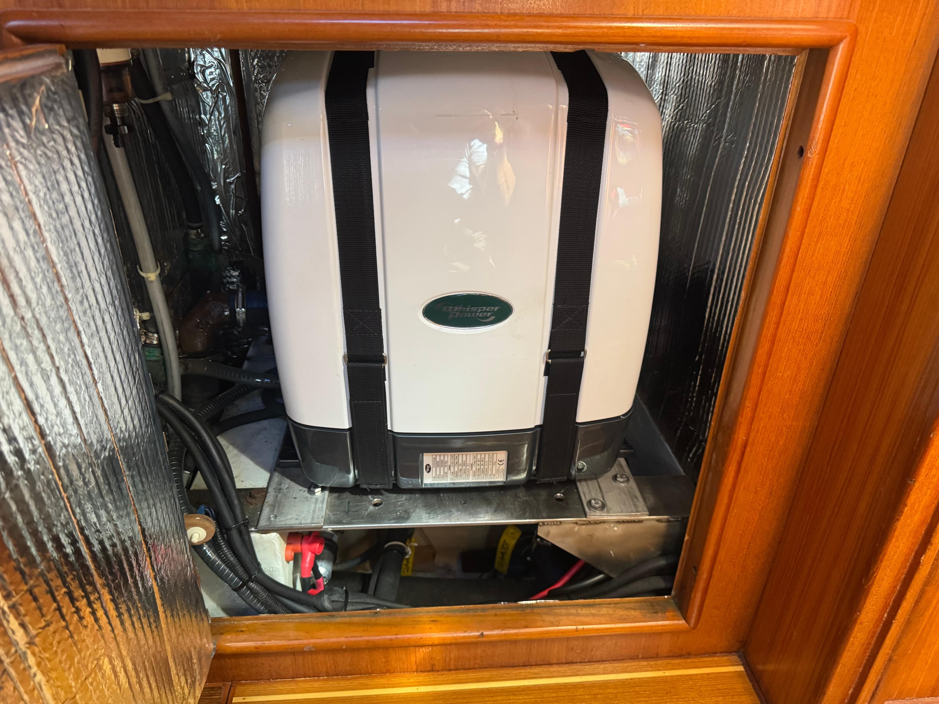 Generator inside a 2002 Hunter 466 yacht, secured with straps and surrounded by insulation.