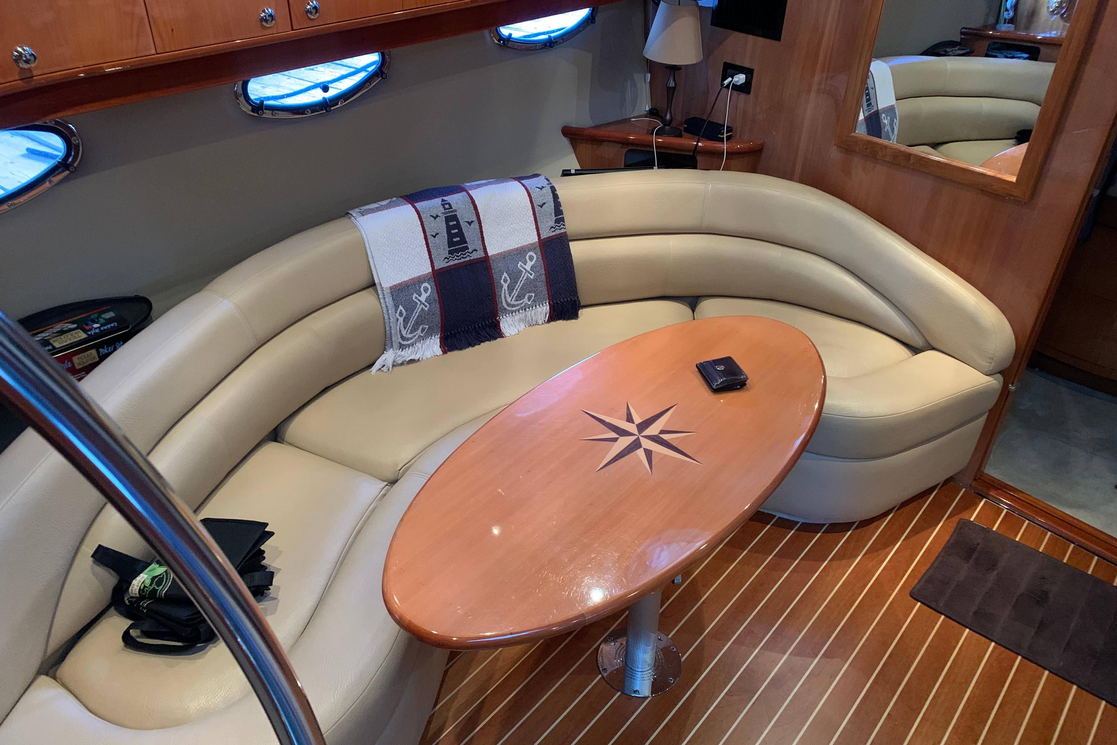 Luxurious 2007 Regal Commodore 4460 yacht interior with curved seating and wooden table.