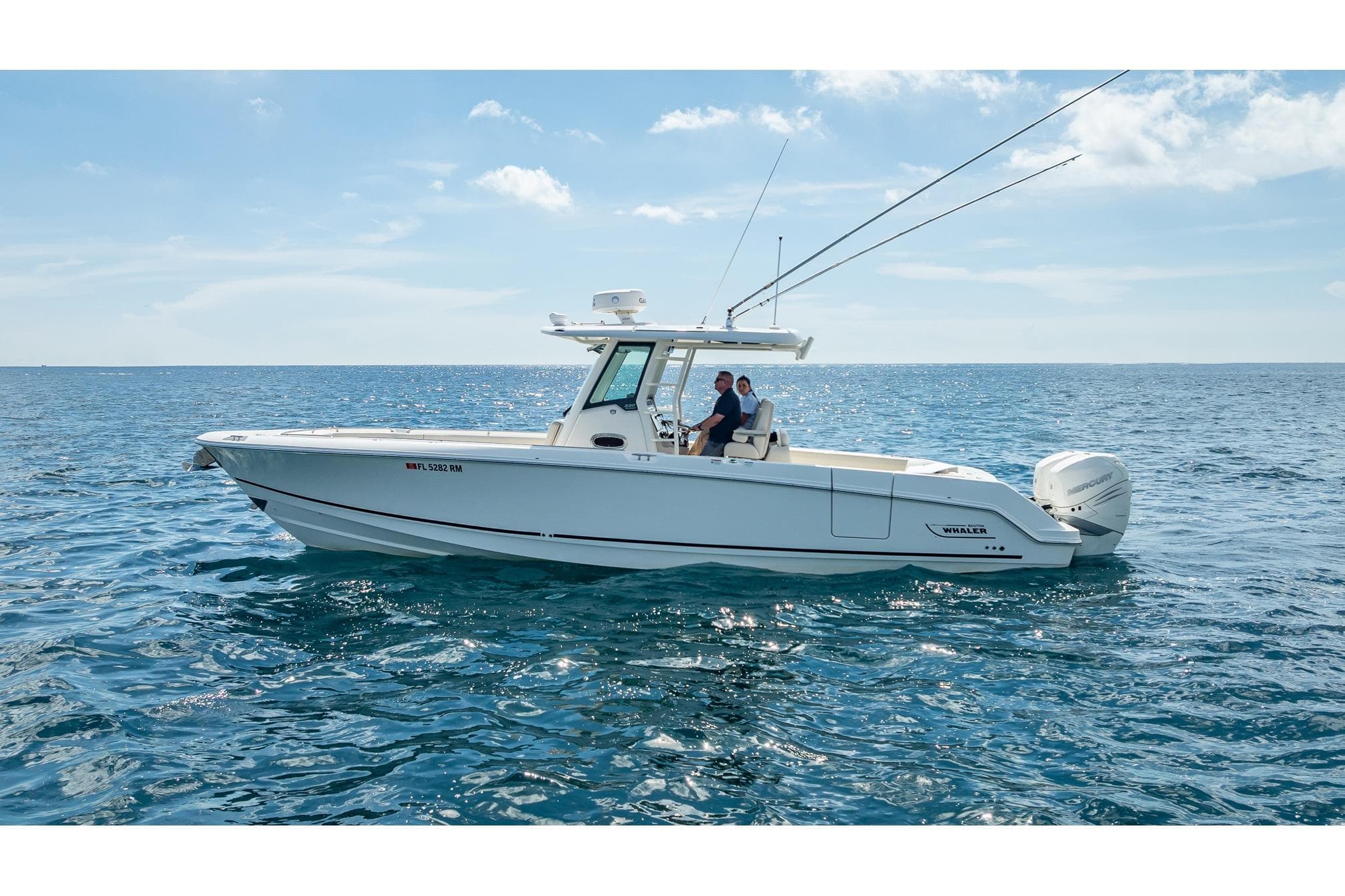 2017 Boston Whaler 330 Outrage boat cruising on open sea under clear sky.