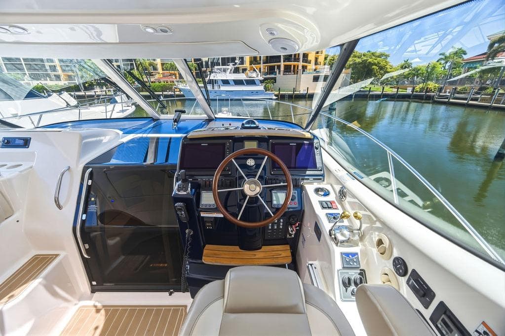 Interior view of 2008 Tiara Yachts 3900 Sovran helm with modern controls and waterfront backdrop.