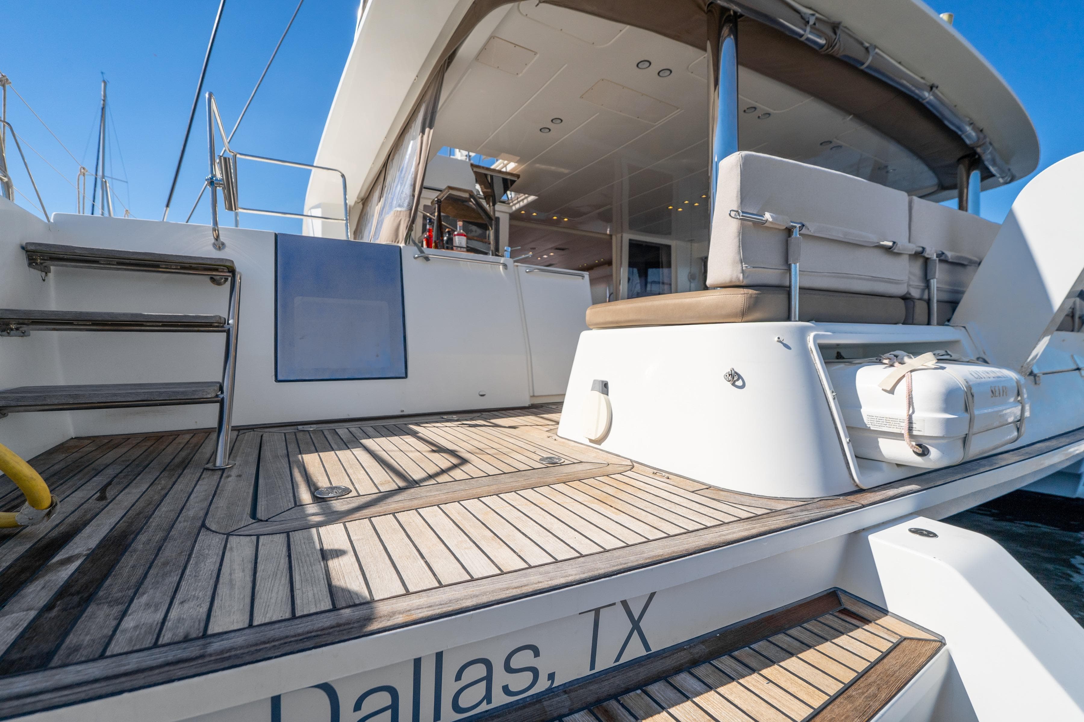 Luxury Lagoon 560 yacht deck, 2012 model, featuring elegant seating and wooden flooring.