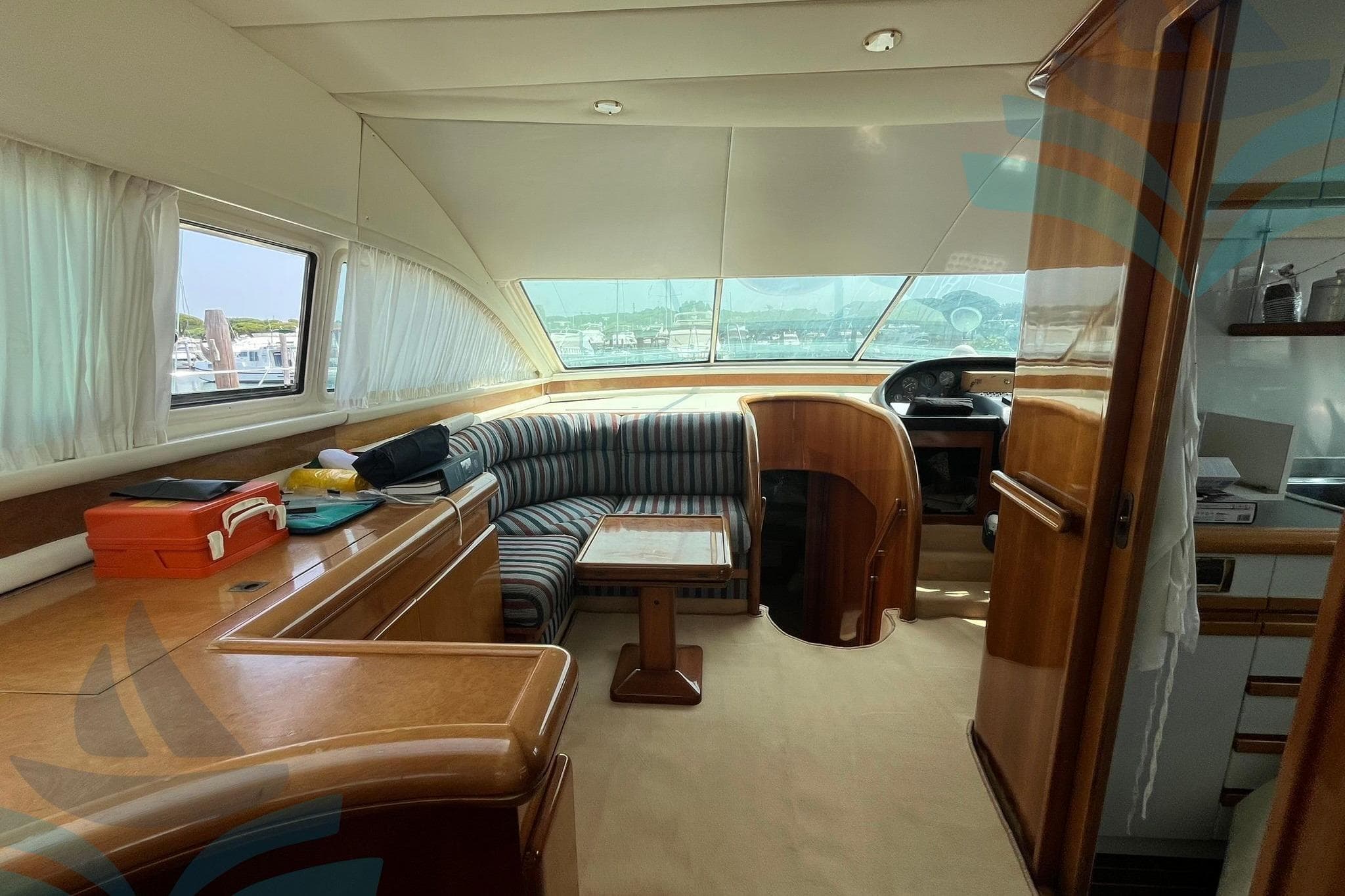 Luxurious 1995 C.N. VZ S.r.l. VZ 18 yacht interior with striped seating and wooden finishes.