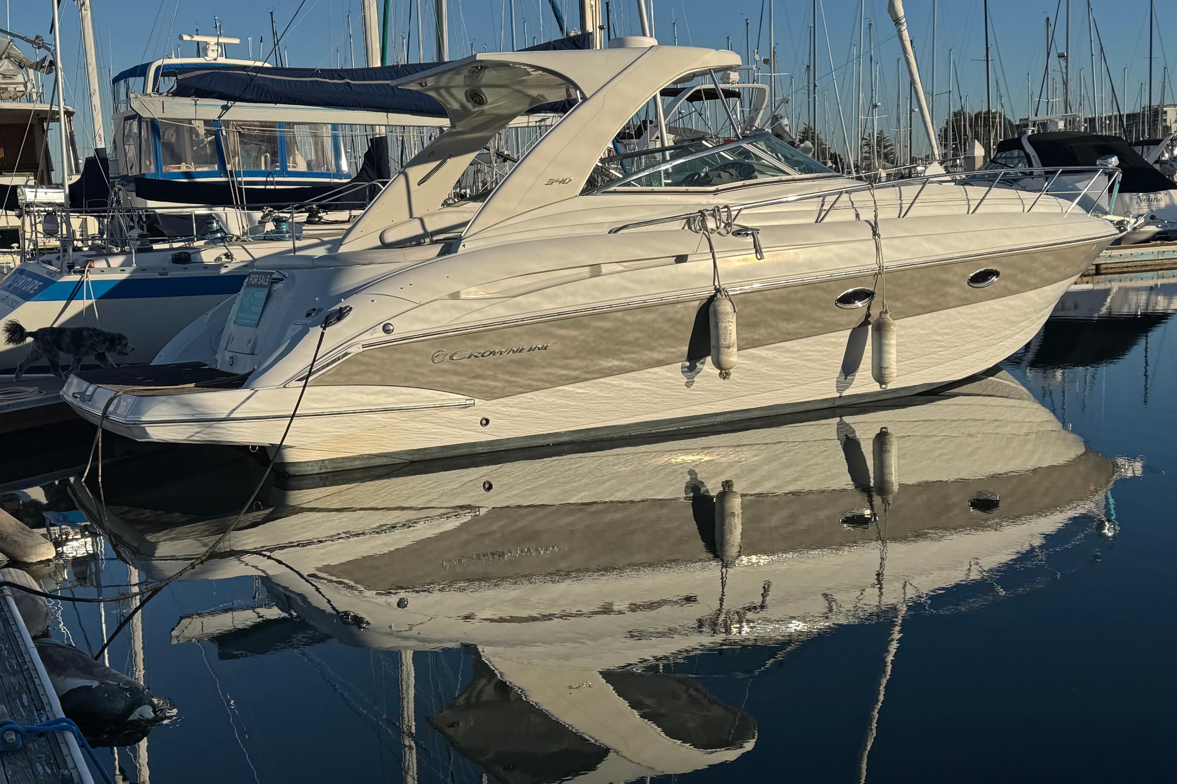 2008 Crownline 340 CR yacht docked in marina, reflecting on calm water.