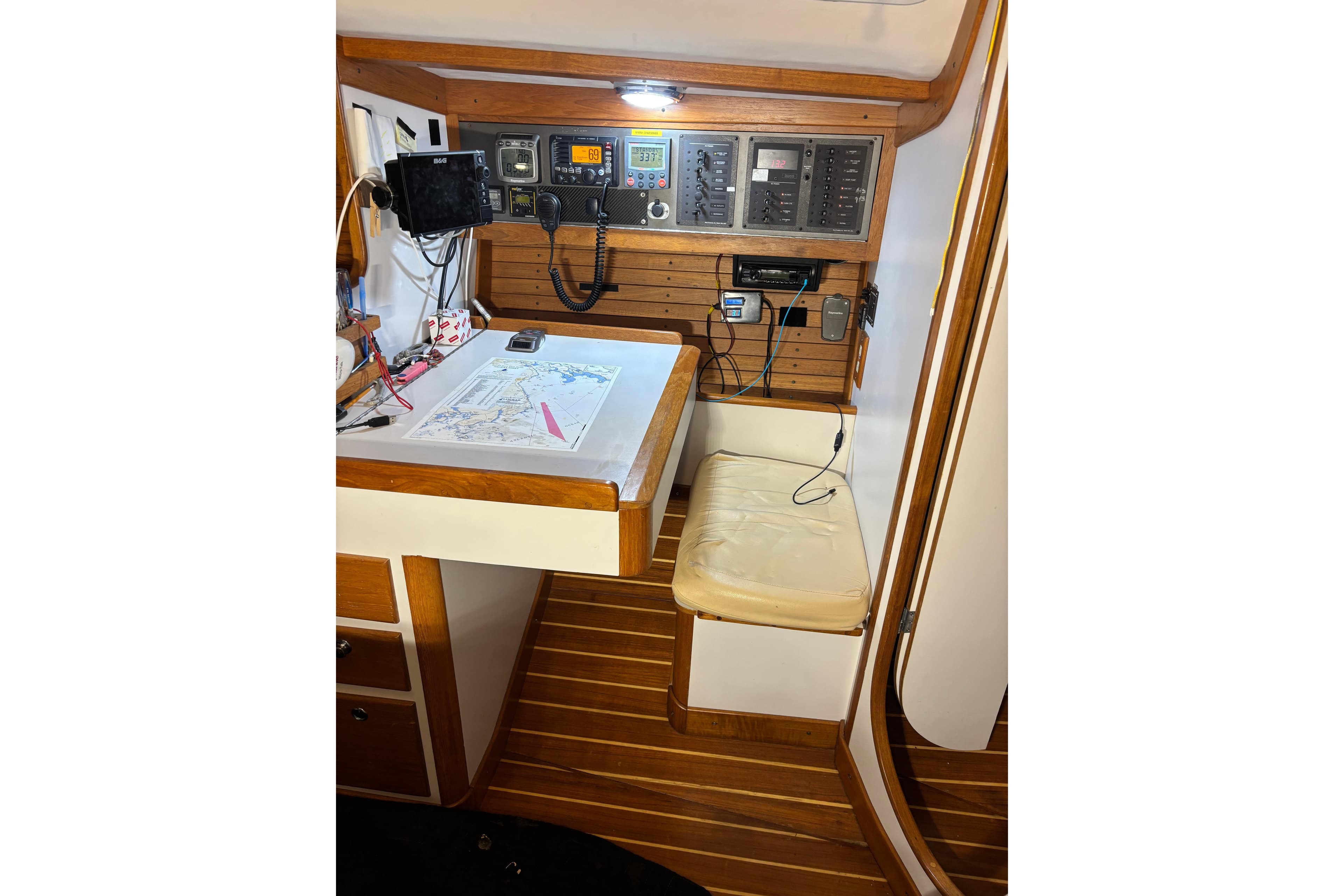 Navigation station in 2002 J Boats J/120 sailboat with chart and communication equipment.