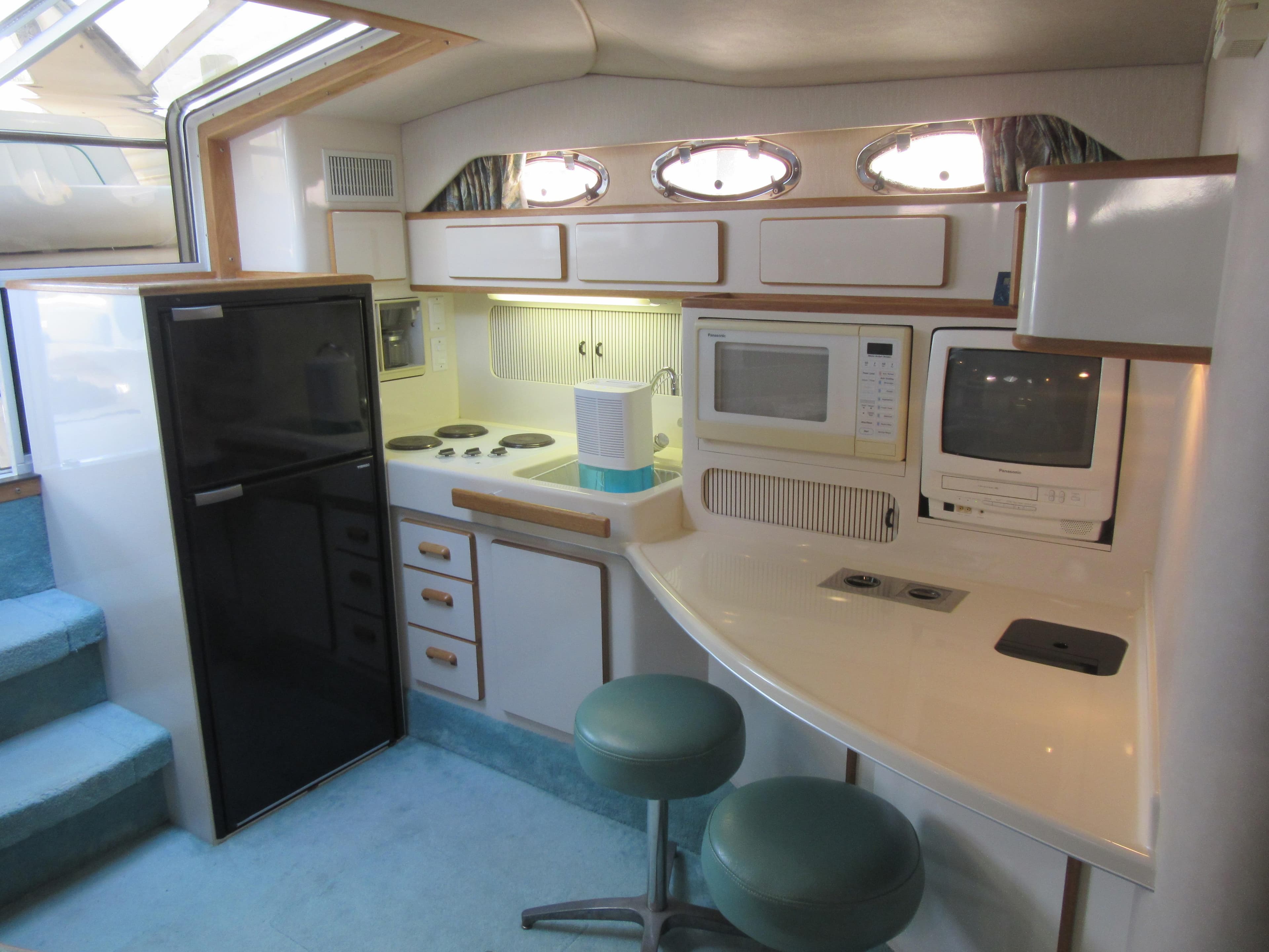 1995 Sea Ray 400 Express Cruiser kitchen with appliances and seating.