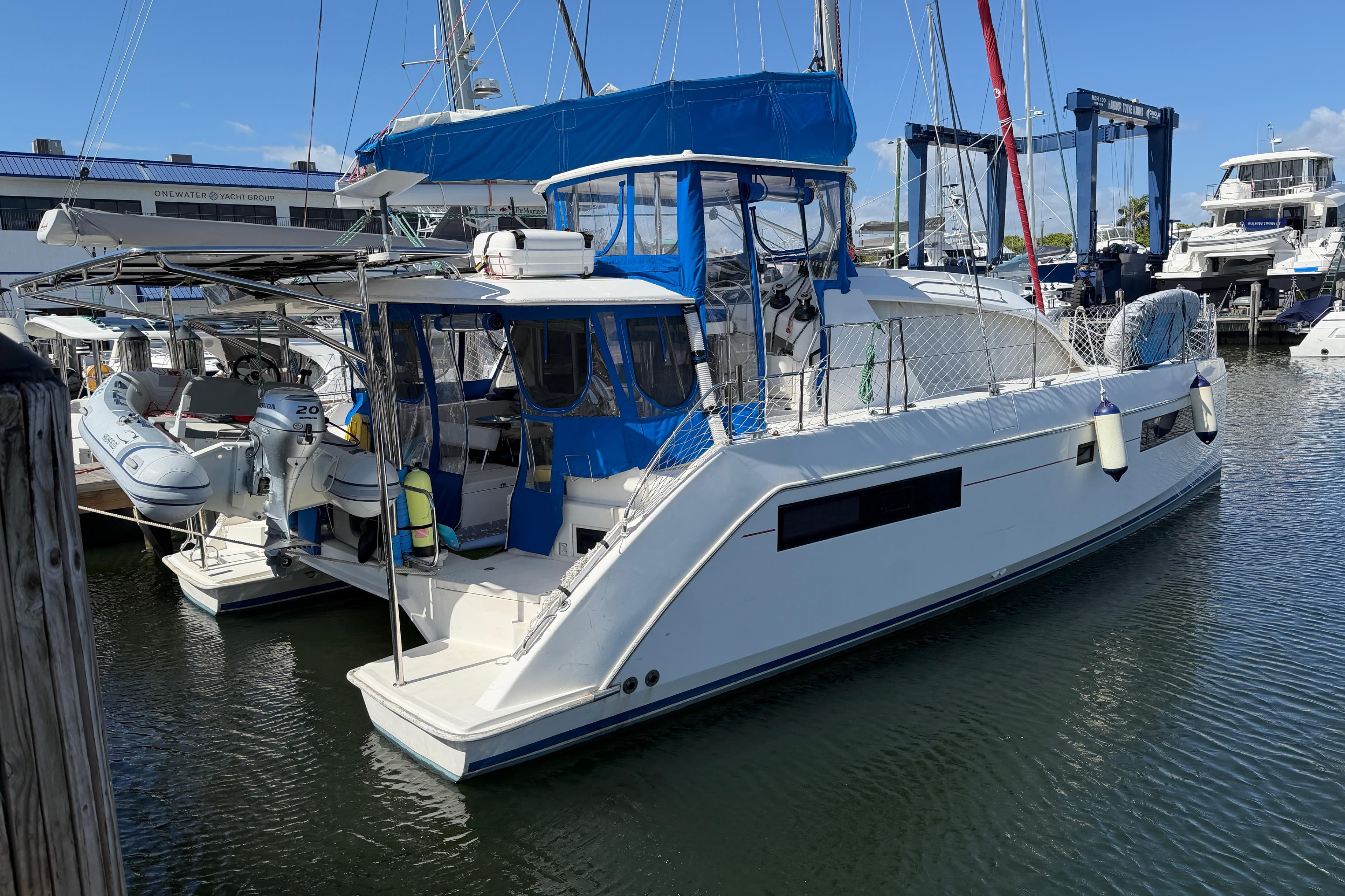 2017 Leopard 40 catamaran docked at marina with blue canopy and dinghy.
