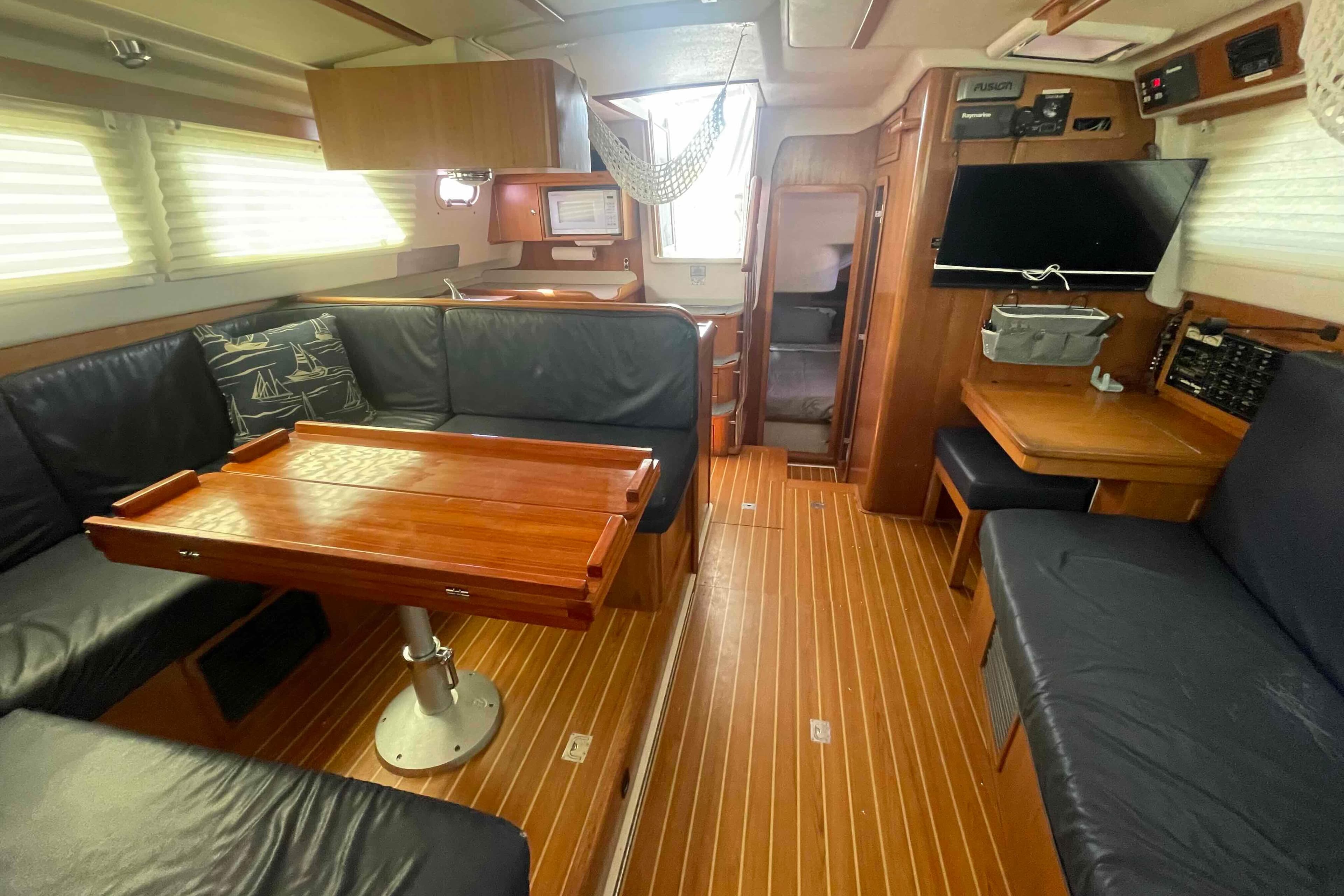 Interior of 2013 Catalina Morgan 440 yacht with wood flooring and leather seating.