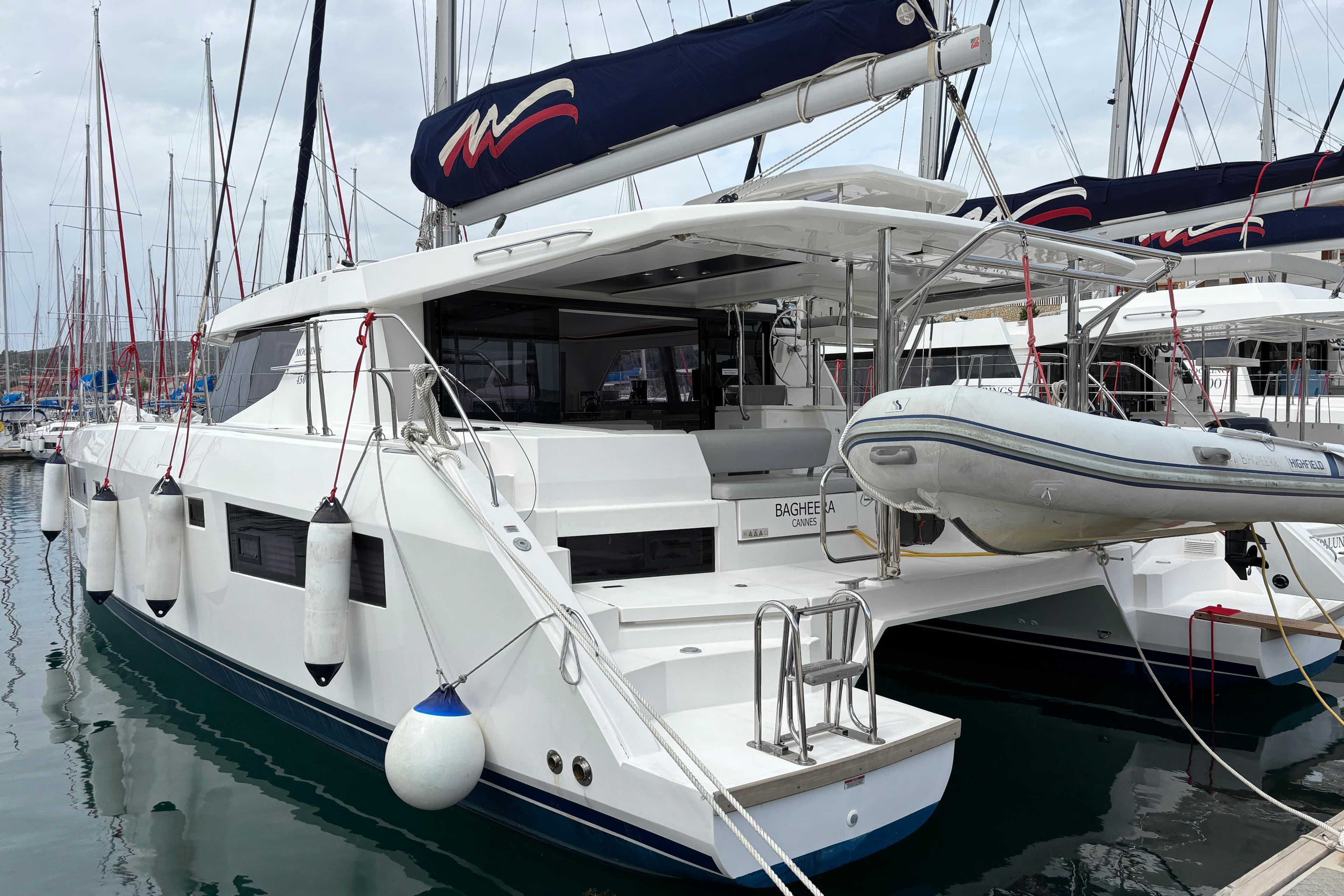 2020 Leopard 45 catamaran docked with dinghy, featuring sleek design and spacious deck.