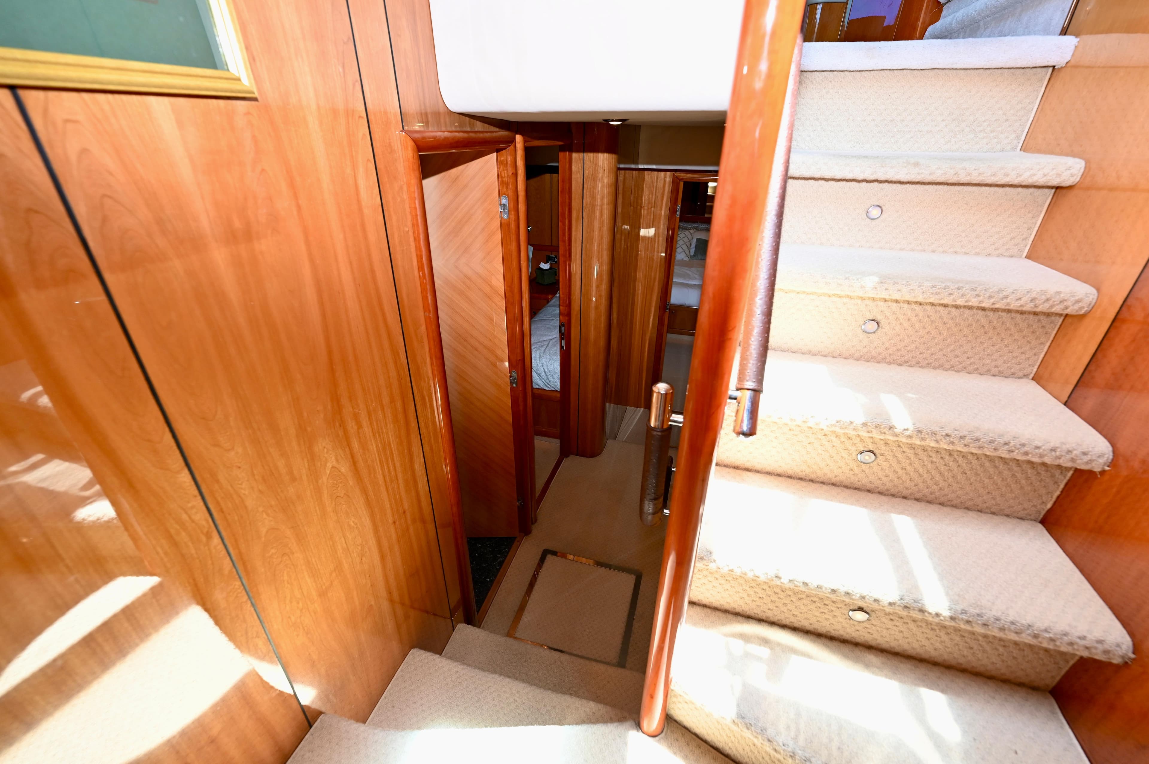 Interior staircase of 2005 Sunseeker 82 Yacht with wooden paneling and carpeted steps.