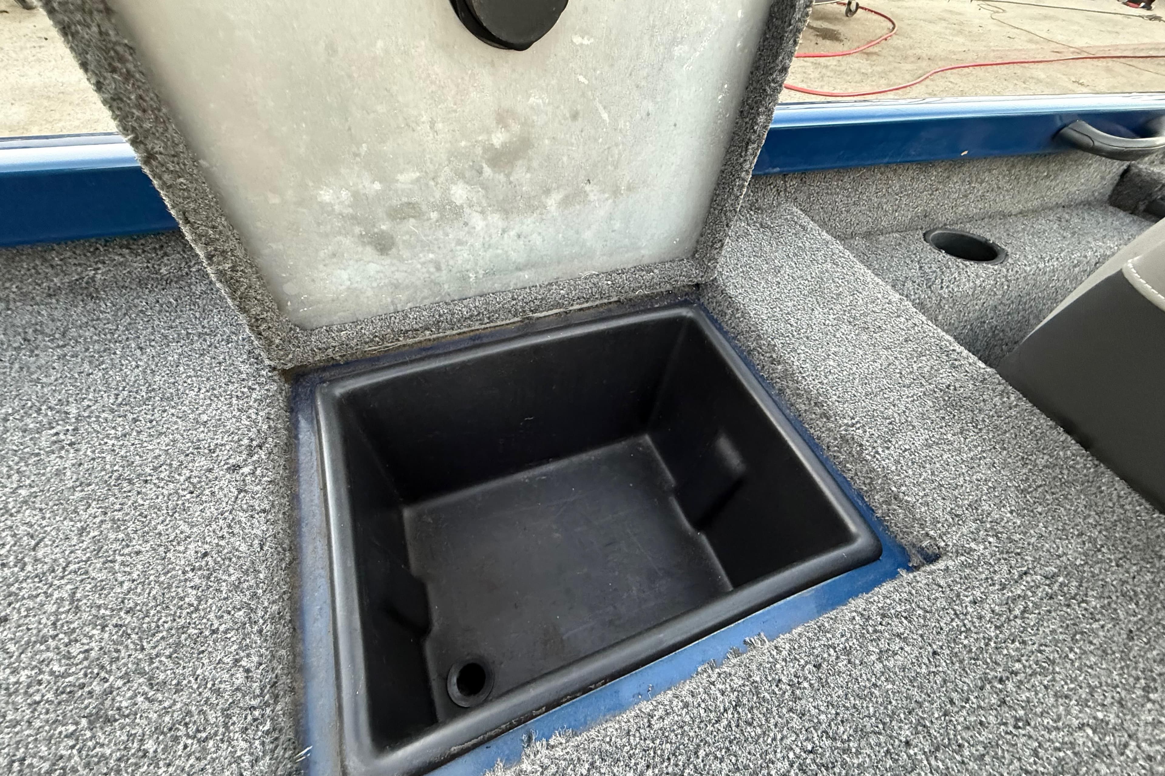 Open storage compartment in 2020 Triton 17 TX boat, featuring carpeted interior.