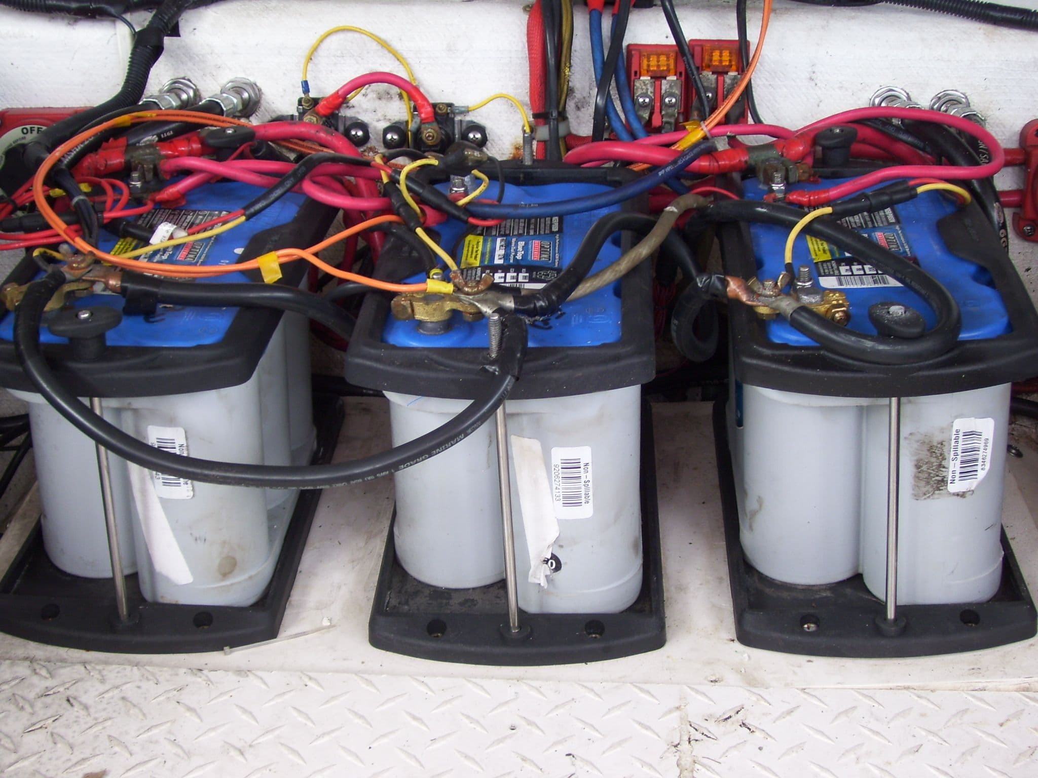 Three marine batteries with colorful wiring in a 2002 Mares 38 High Performance boat.