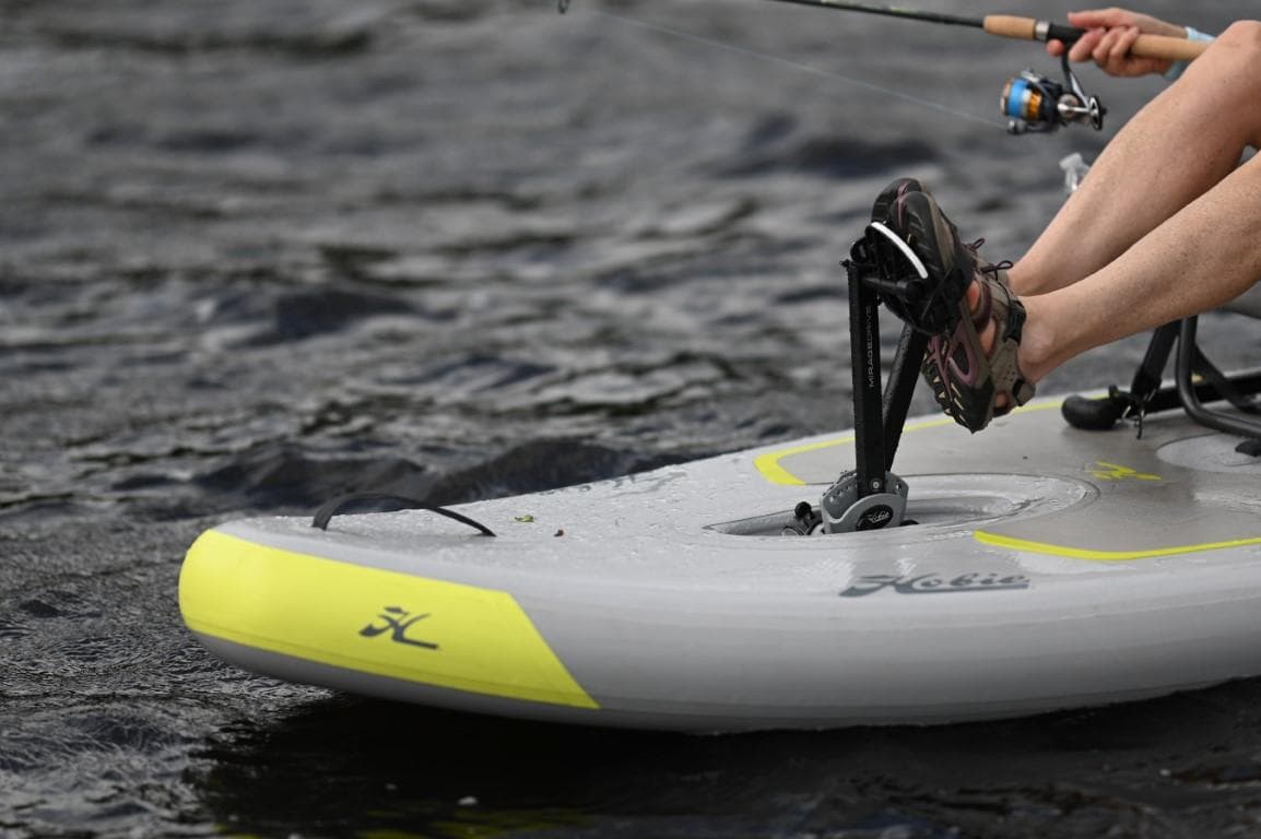 Hobie iTrek 9 Ultralight 2025 kayak on water, featuring pedal system and fishing rod.
