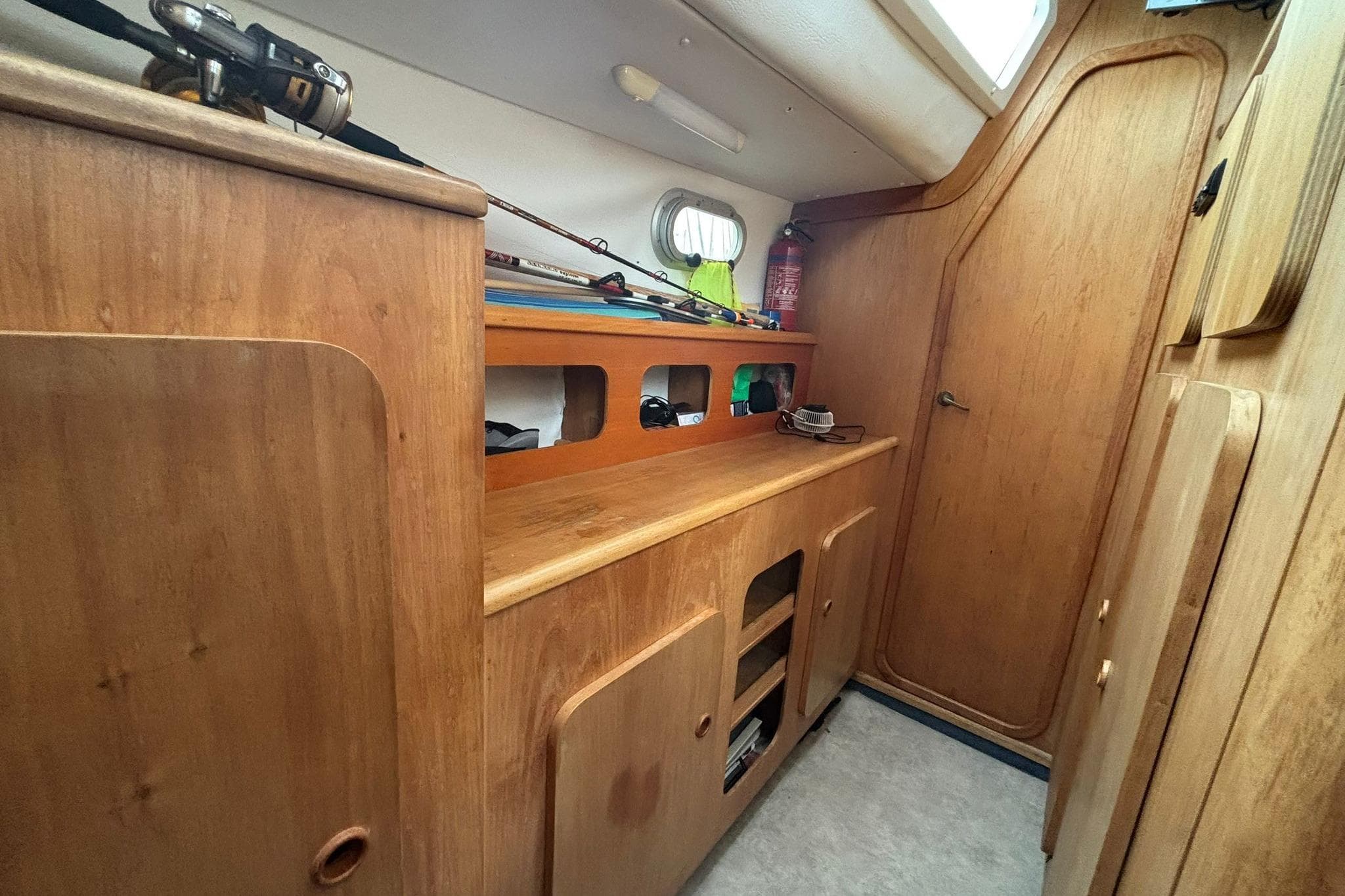 1998 Prout 38 interior with wooden cabinetry and fishing gear storage.