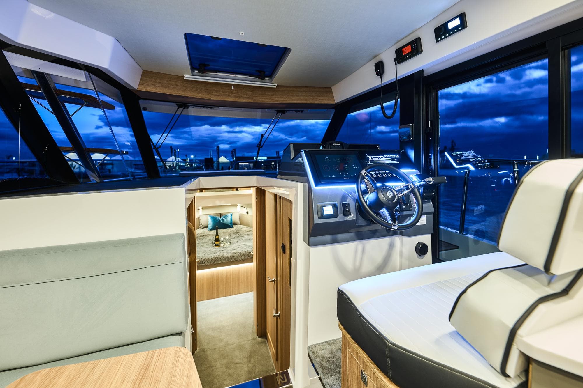 Luxurious interior of 2025 Northman 1300 yacht with modern helm and cozy cabin.