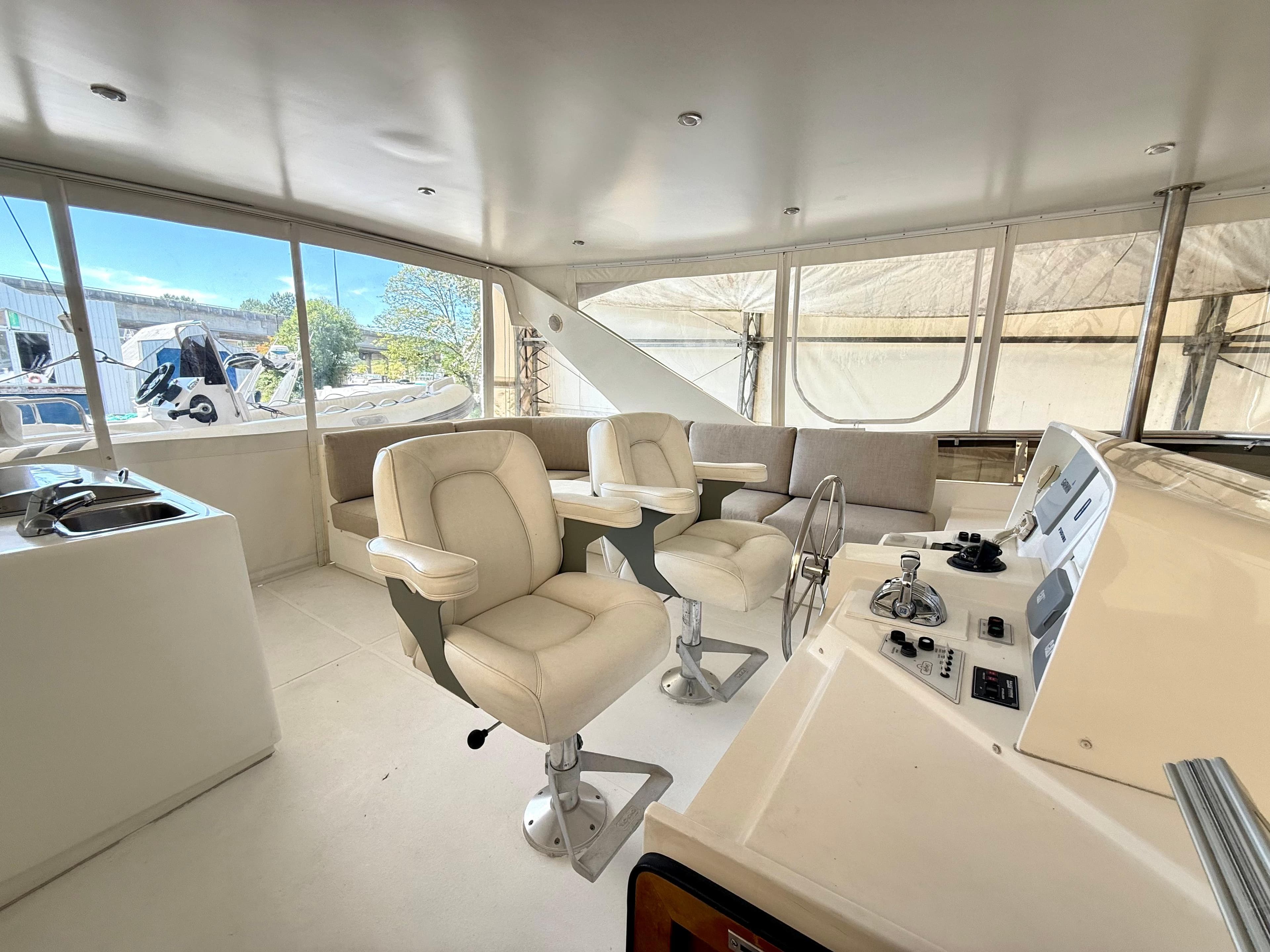 Pilothouse interior of 2001 West Bay Sonship 58, featuring helm chairs and control panel.