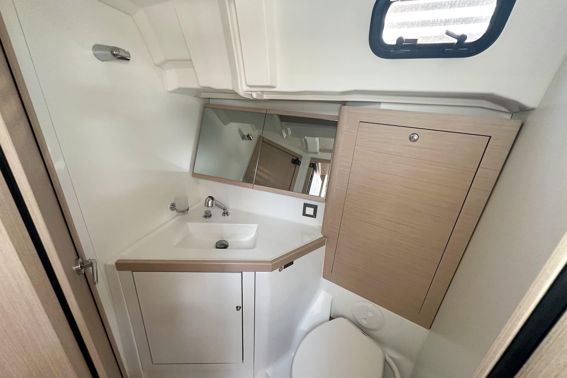 2024 Beneteau Oceanis 46.1 bathroom with modern sink, mirror, and storage cabinet.