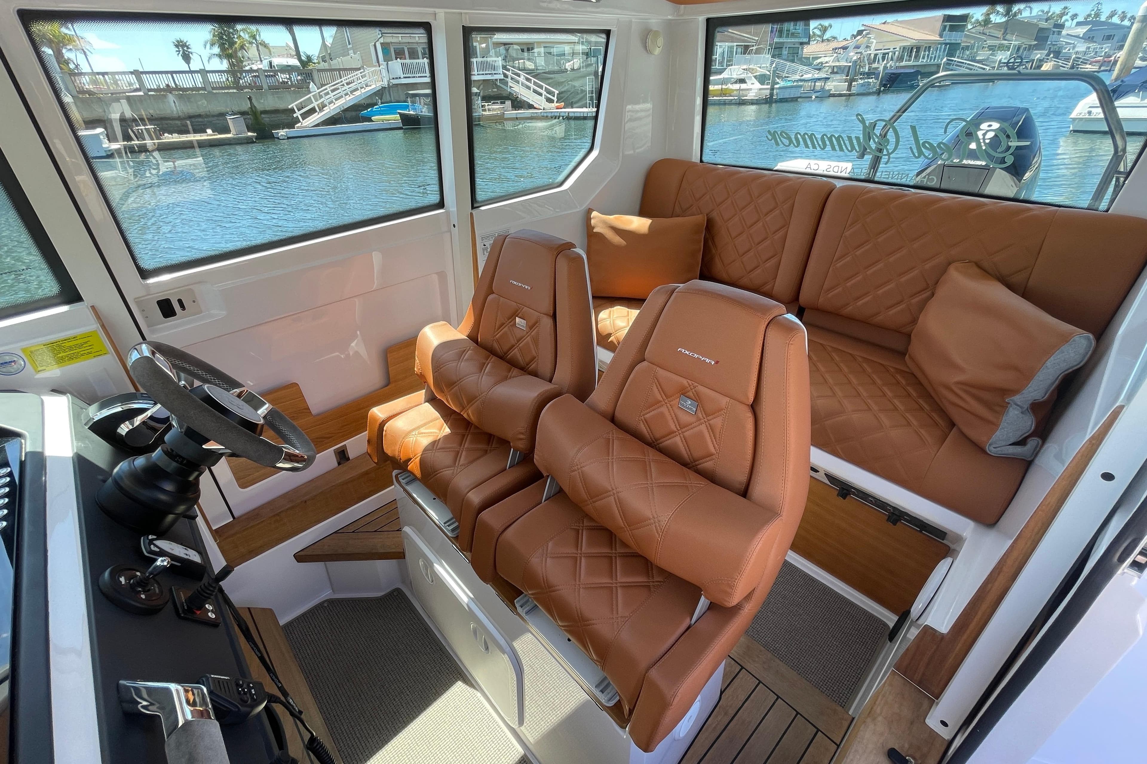 Luxurious interior of 2022 Axopar Brabus 28 Cabin with leather seating and waterfront view.