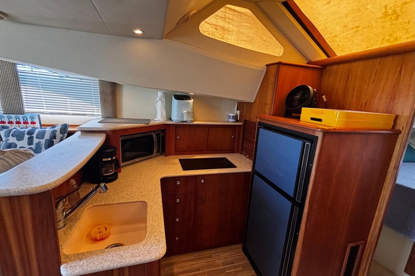 Interior of 2001 Silverton 330 Sport Bridge yacht kitchen with appliances and wood cabinetry.