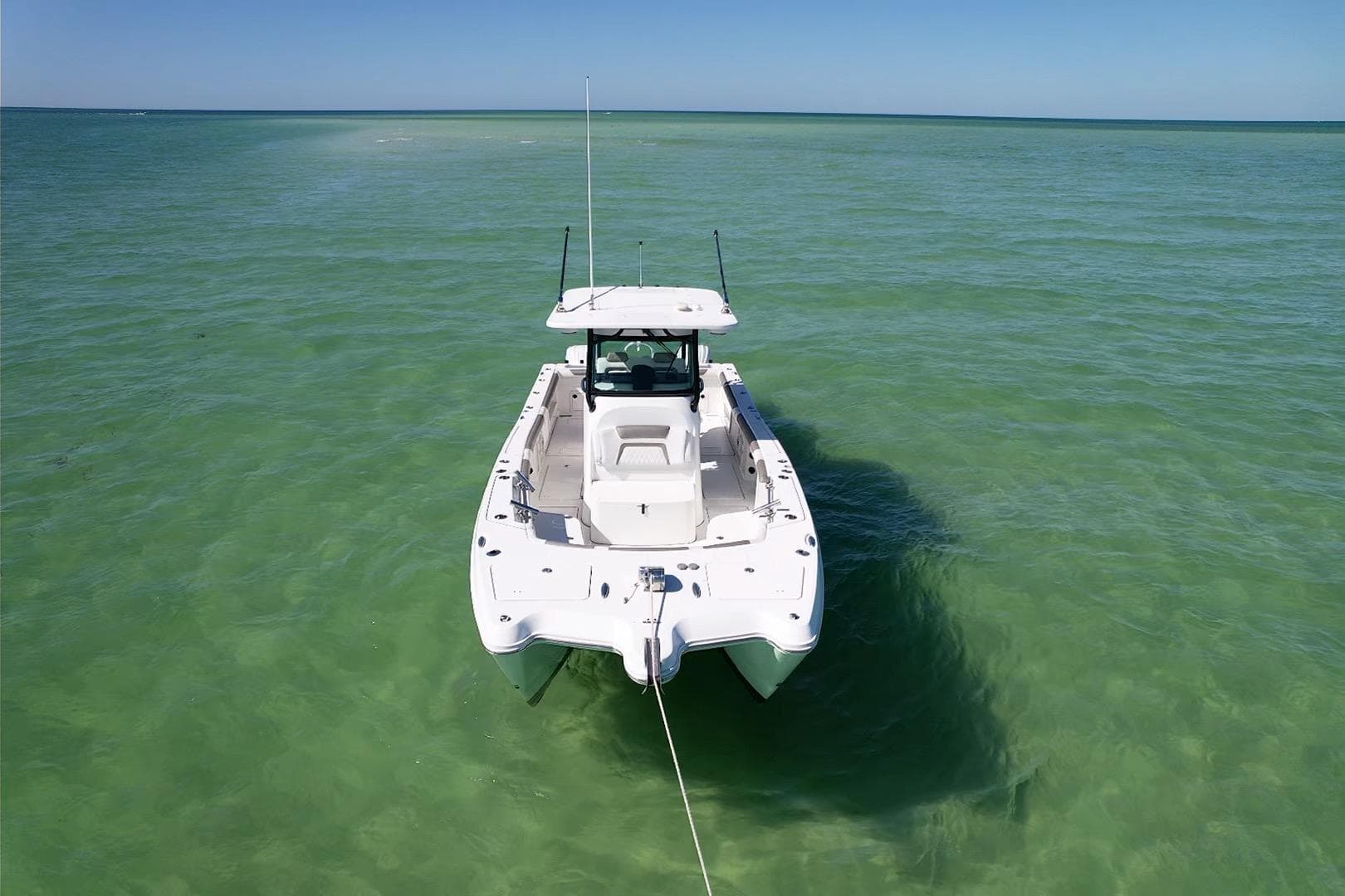 2023 World Cat 325 CC boat anchored in clear turquoise water.