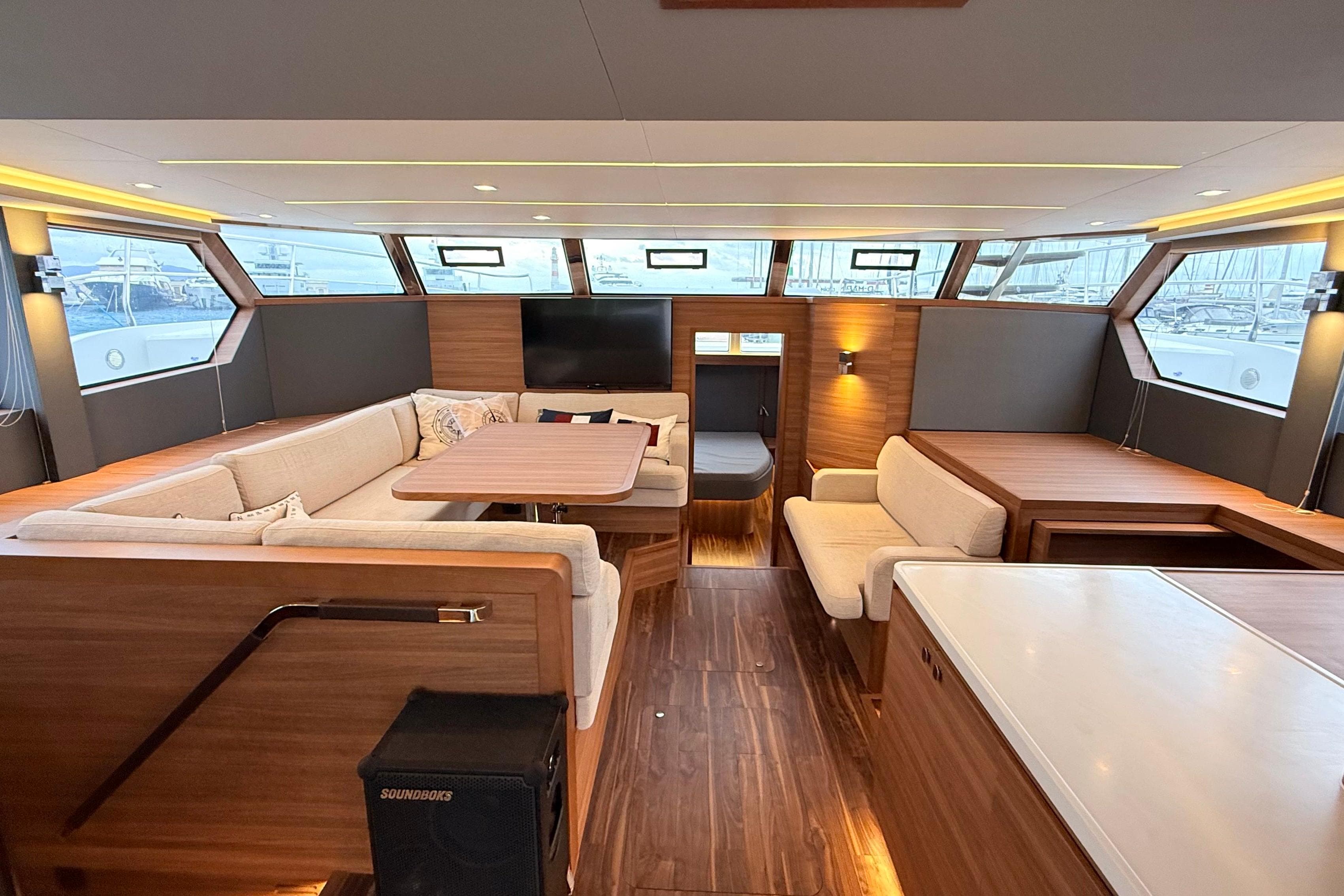 Luxurious interior of 2025 Aquila 50 Yacht with modern seating and wood finishes.