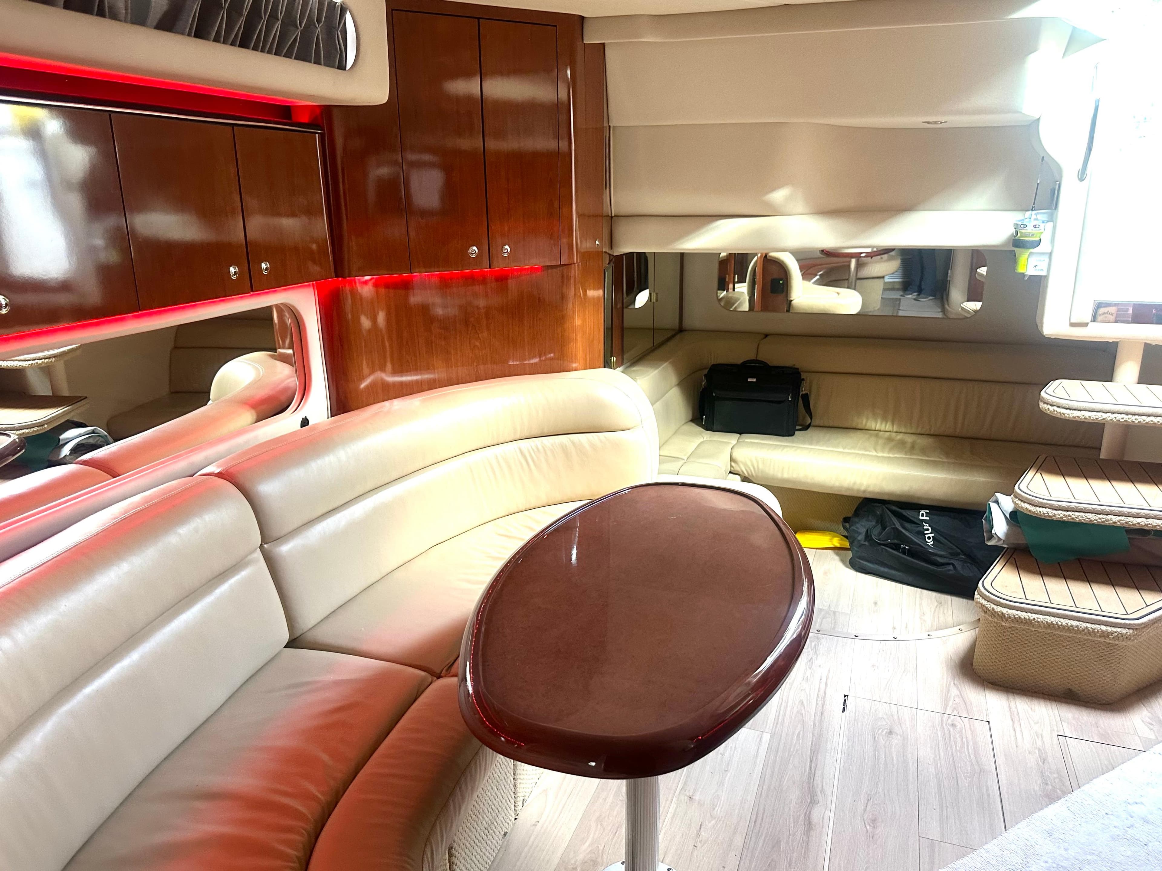 Interior of 2003 Sea Ray 380 Sundancer yacht with elegant seating and wooden cabinetry.