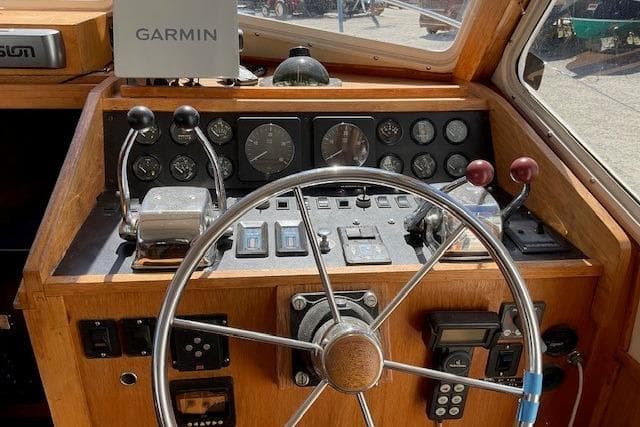 1990 Sabreline 36 Fast Trawler helm with Garmin navigation and classic wooden dashboard.