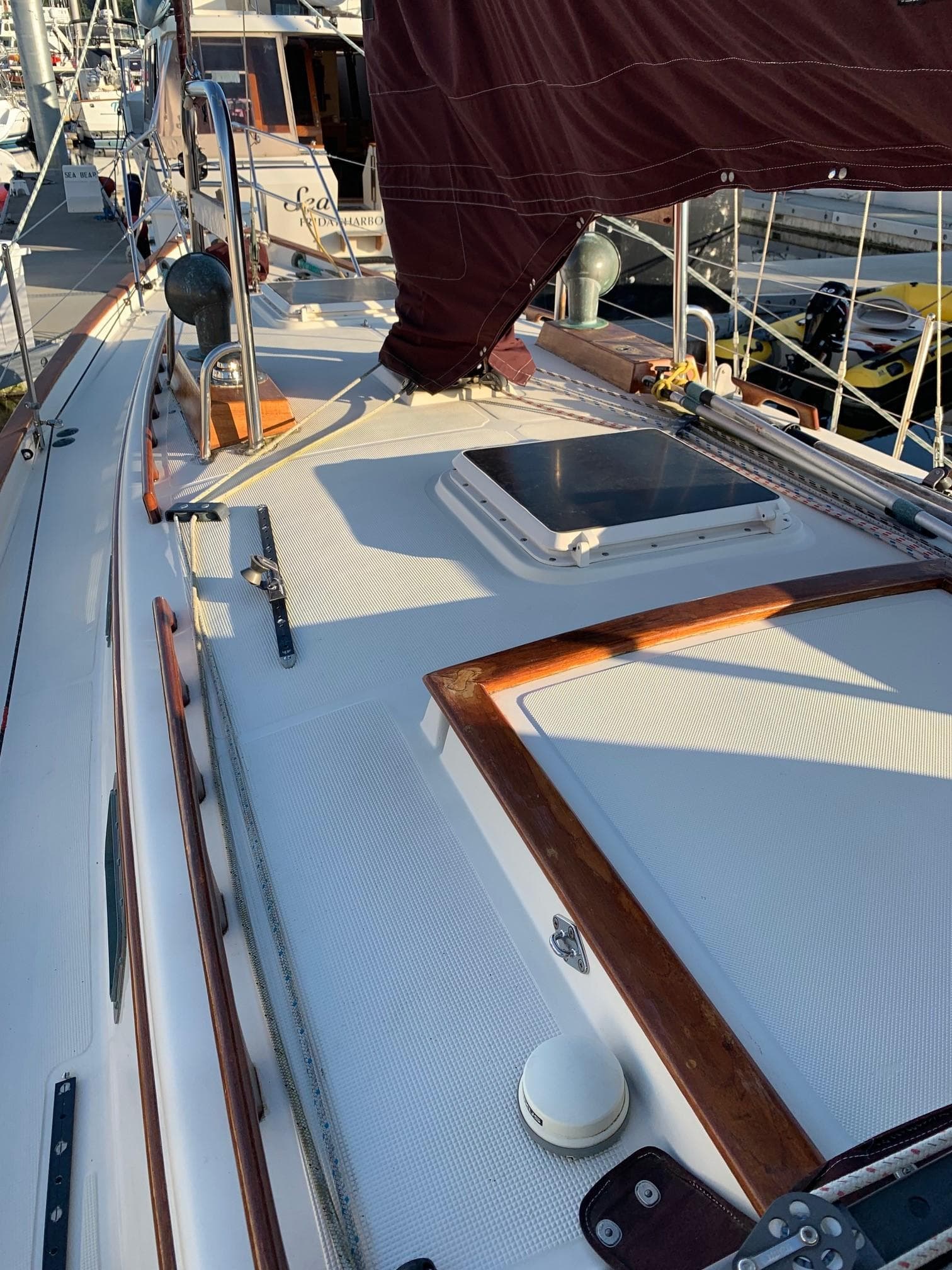 1990 Pacific Seacraft 37 sailboat deck with wooden trim and hatch, docked at marina.
