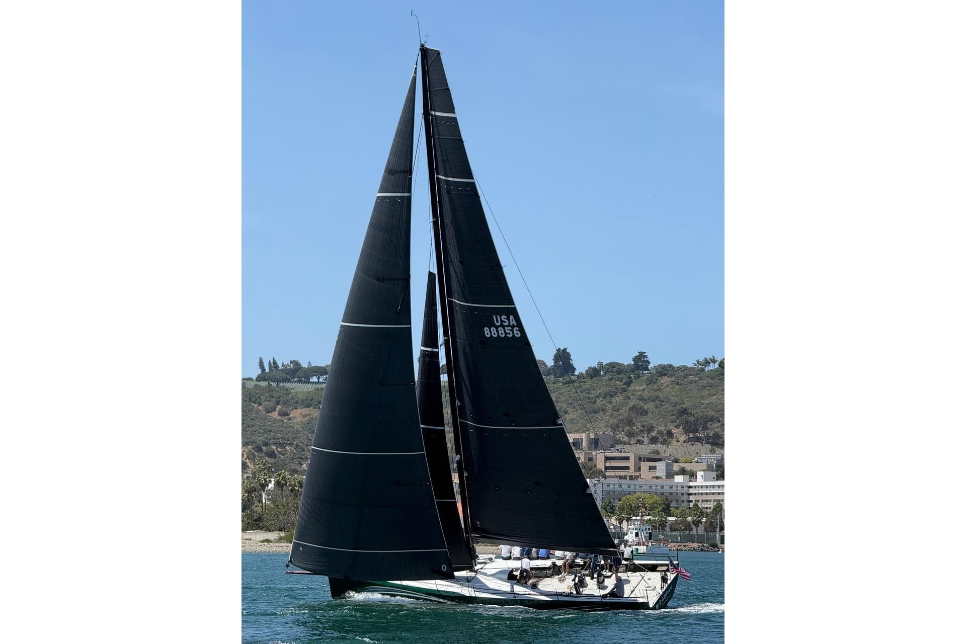 Sleek 2018 Botin 56 sailboat with black sails on a sunny day.