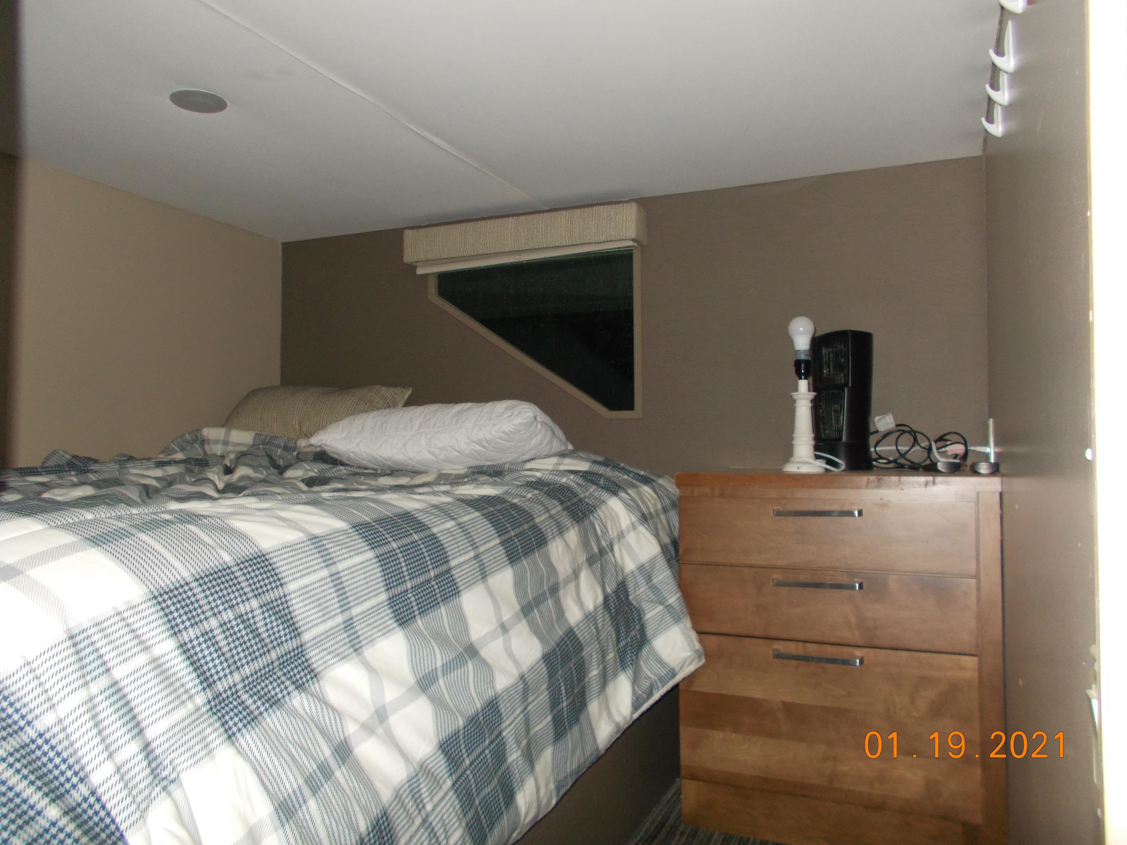 Cozy bedroom in a 2015 Bravada Discovery Trip RV.