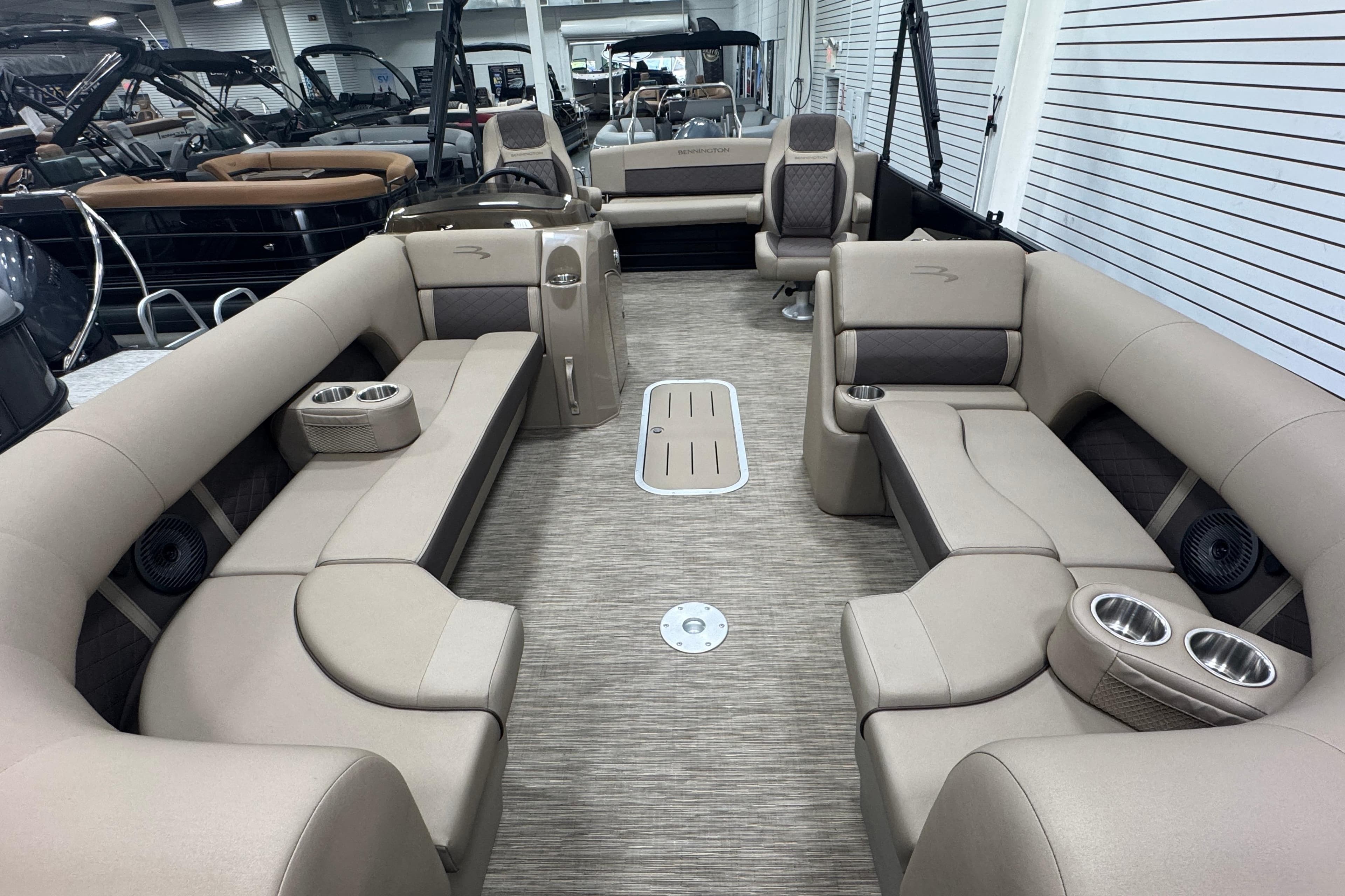 2024 Bennington 24 L Swingback pontoon boat interior with beige seating and cup holders.