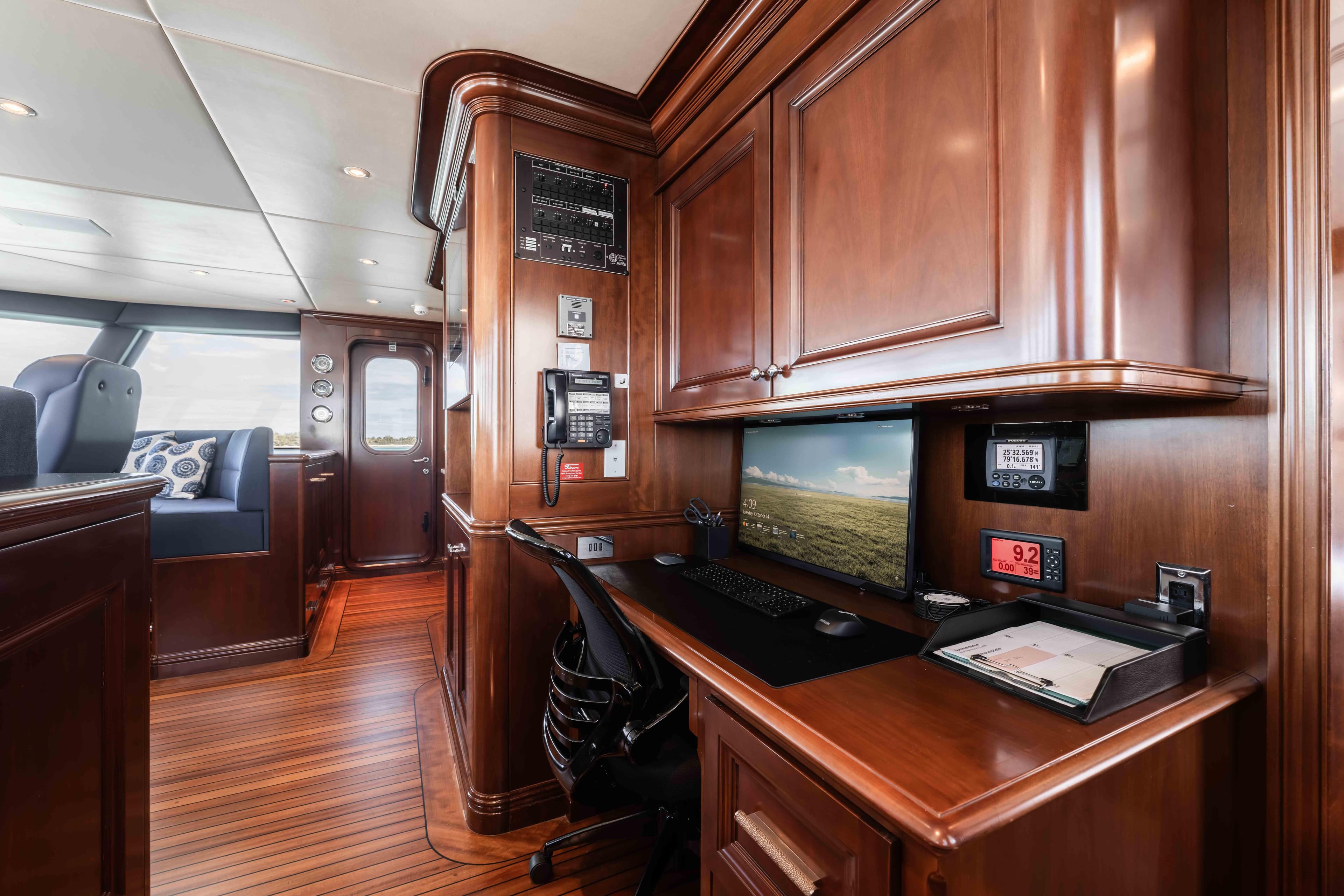 Luxurious 2004 Trinity Yachts motor yacht interior with elegant wood paneling and modern workspace.