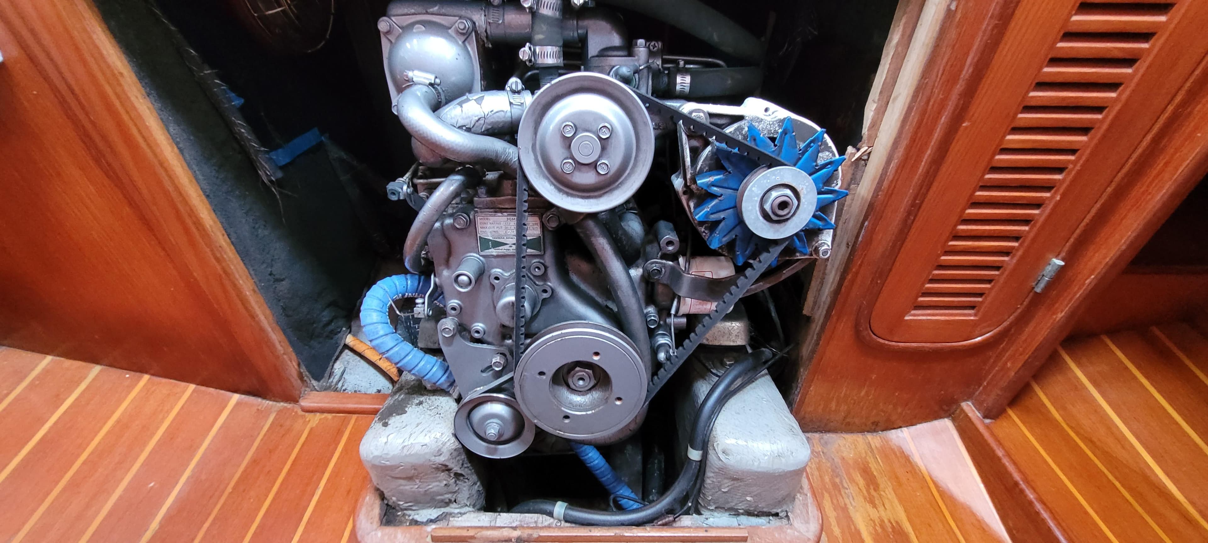 Engine of 1985 Mason 33 Sloop sailboat, showcasing mechanical components and wooden interior.