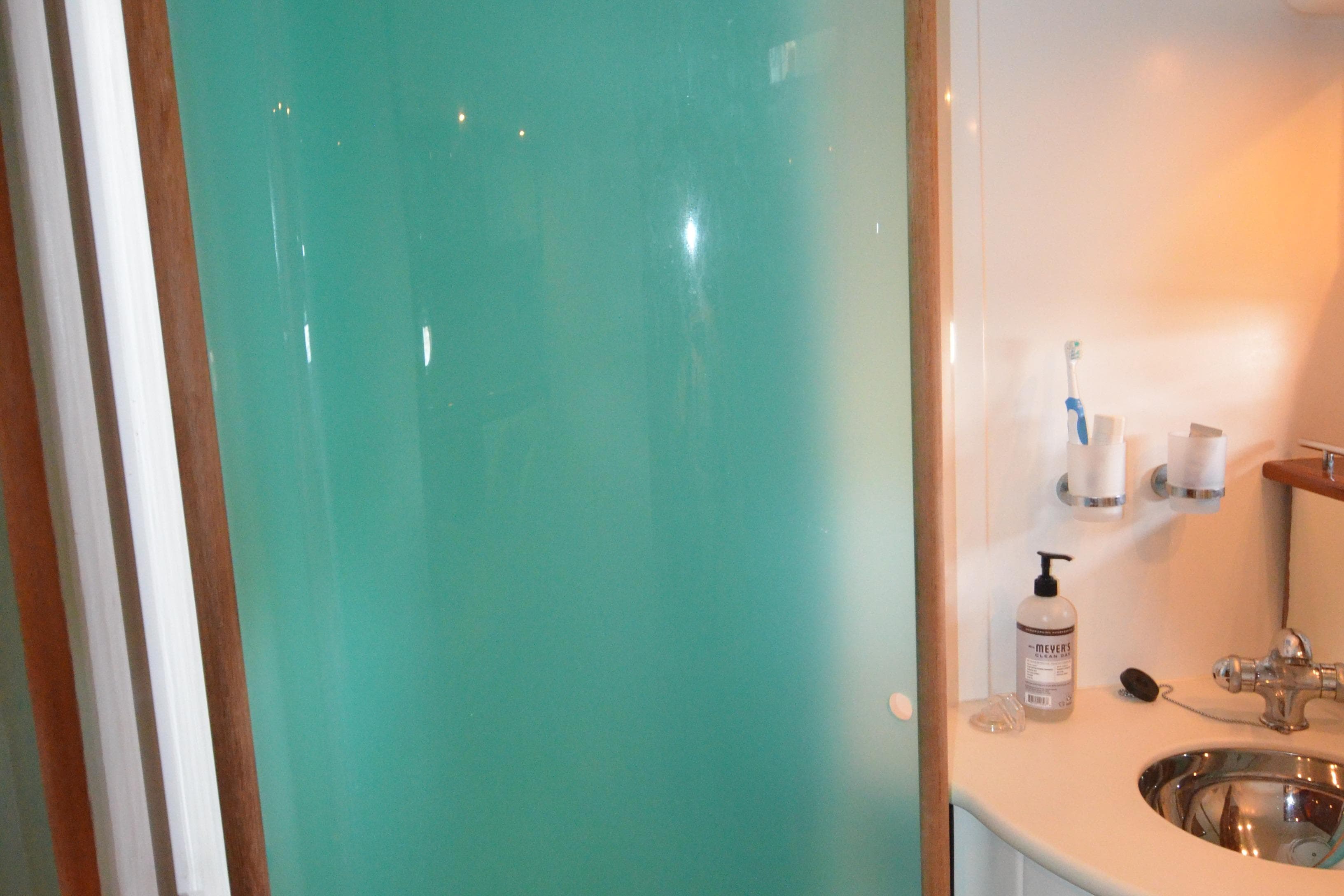 Bathroom interior of 2007 Jeanneau Prestige 46 yacht with frosted glass shower.