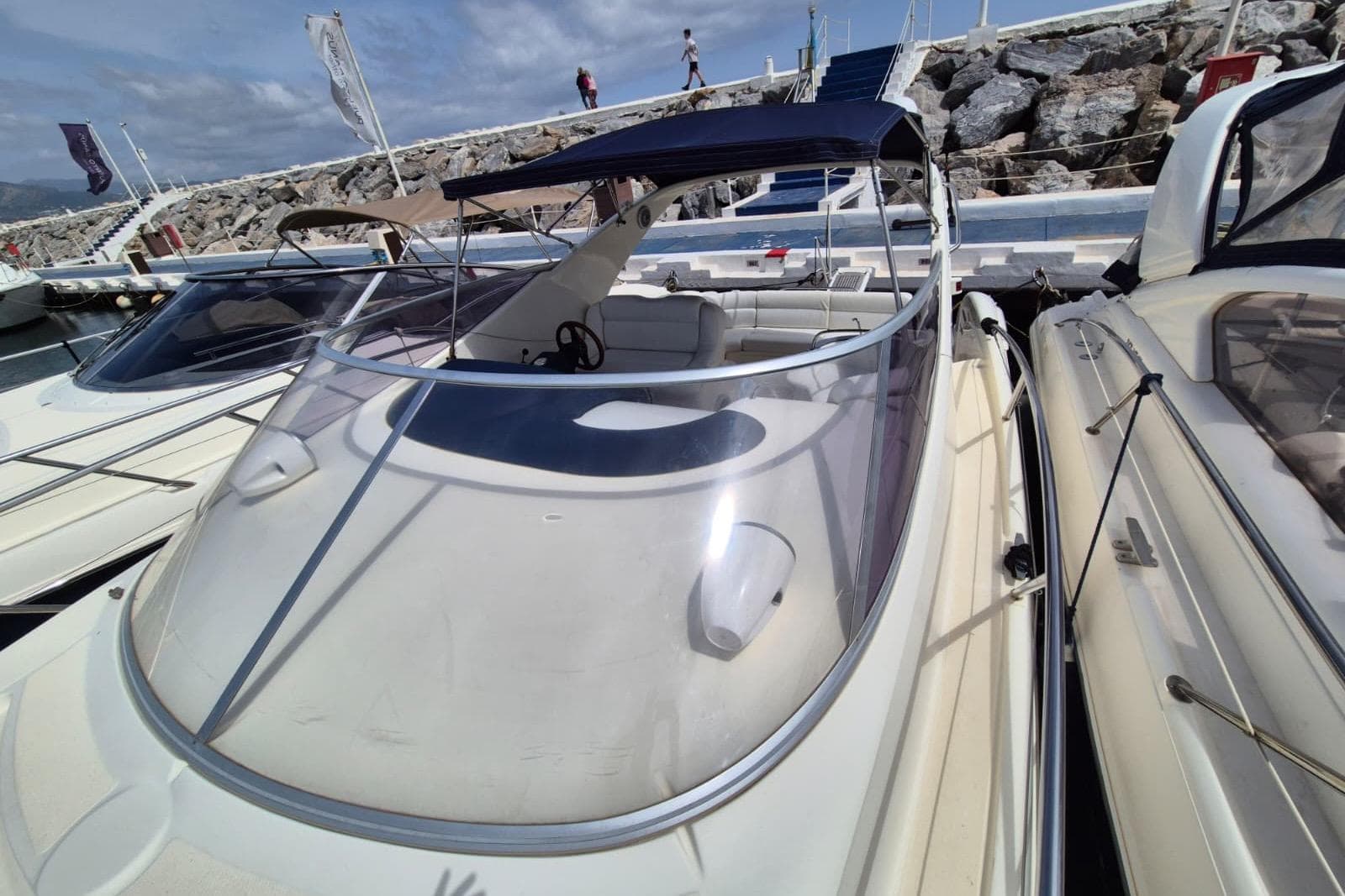 2008 Atlantis 345sc boat docked at marina with blue canopy and clear windshield.