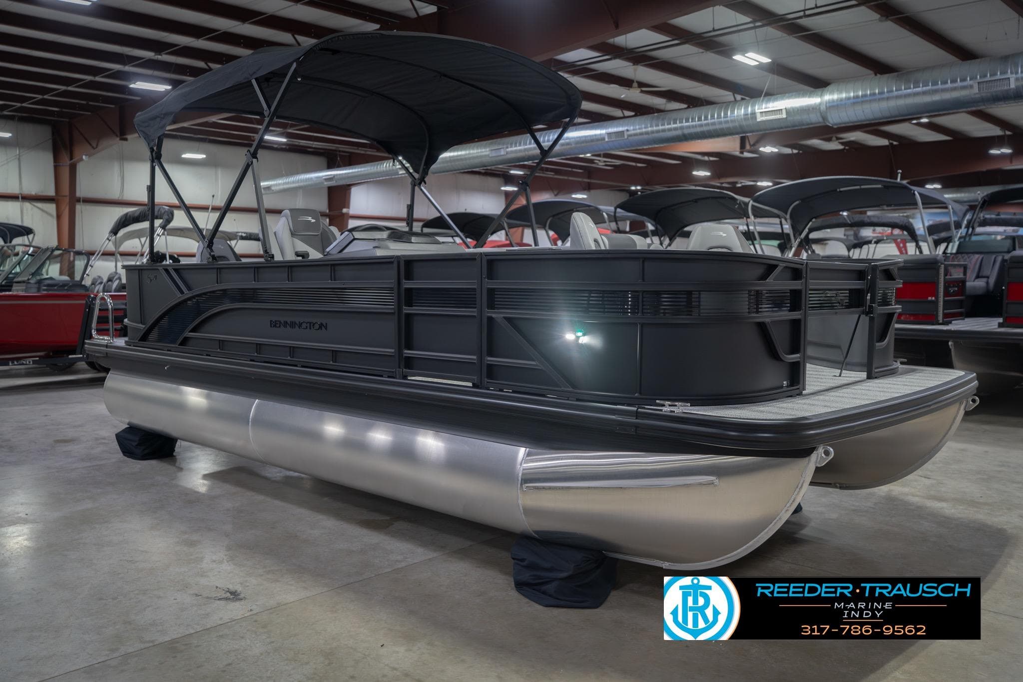 2026 Bennington 21 SF pontoon boat displayed indoors at Reeder Trausch Marine showroom.