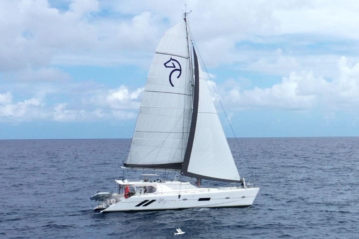 2023 Knysna 500SE catamaran sailing on open ocean under clear skies.