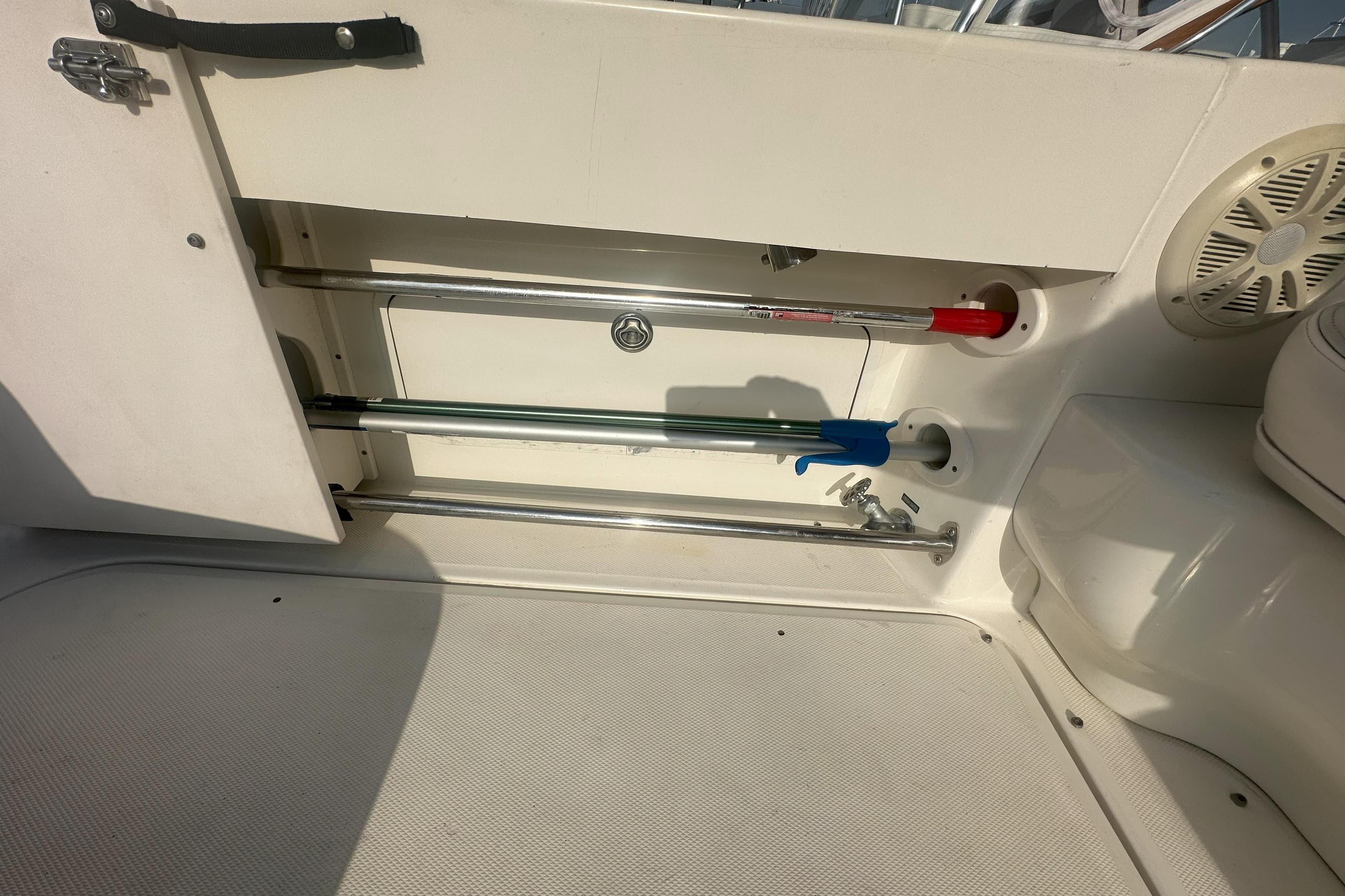 Storage compartment on a 2006 Sea Ray 290 Amberjack boat, featuring rods and equipment.