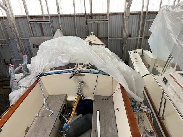 Herreshoff 42 sailboat from 2003 stored indoors, partially covered with plastic.