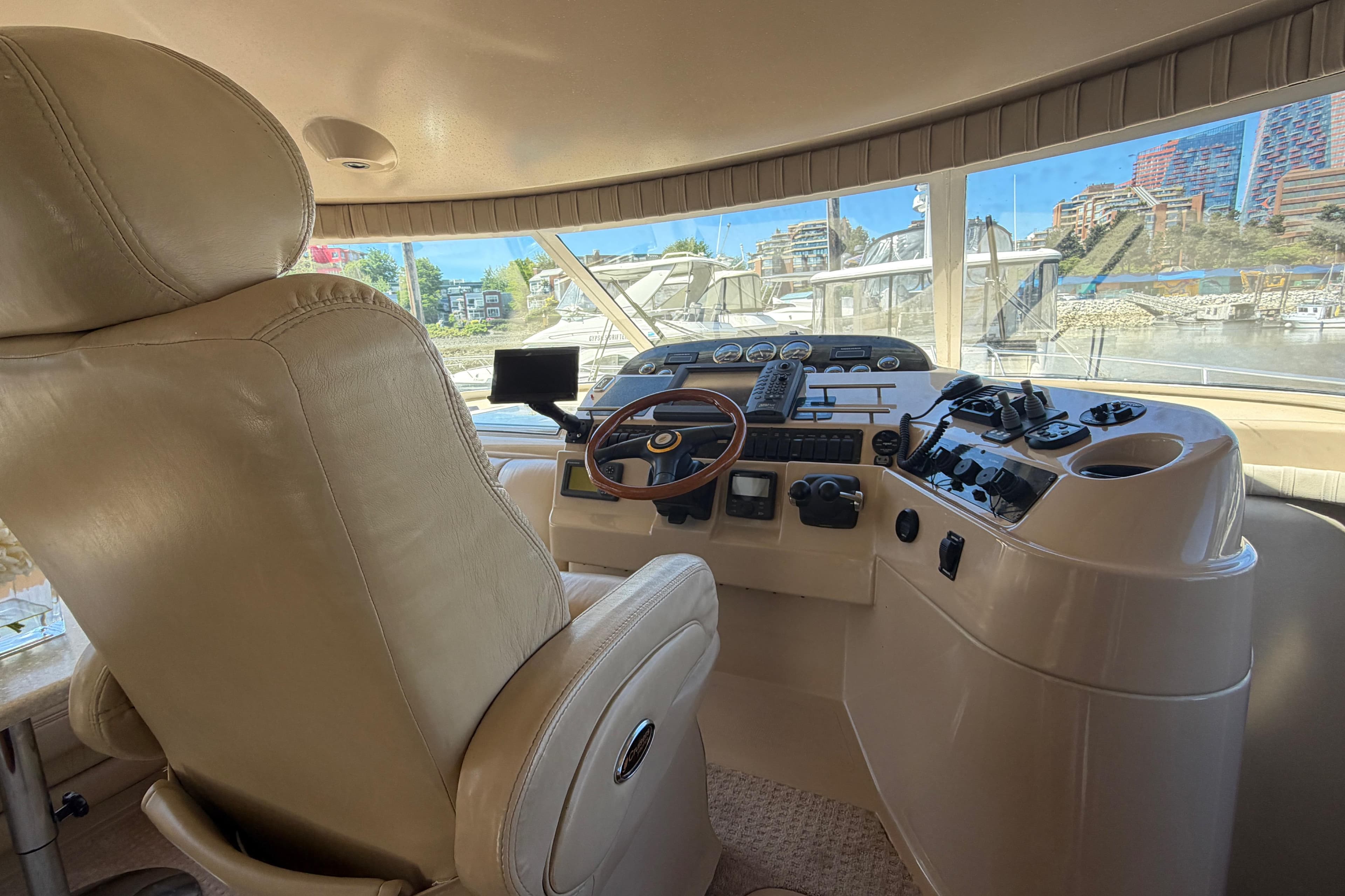 Interior helm of 2001 Cruisers Yachts 5000 Sedan Sport with leather seating and control panel.