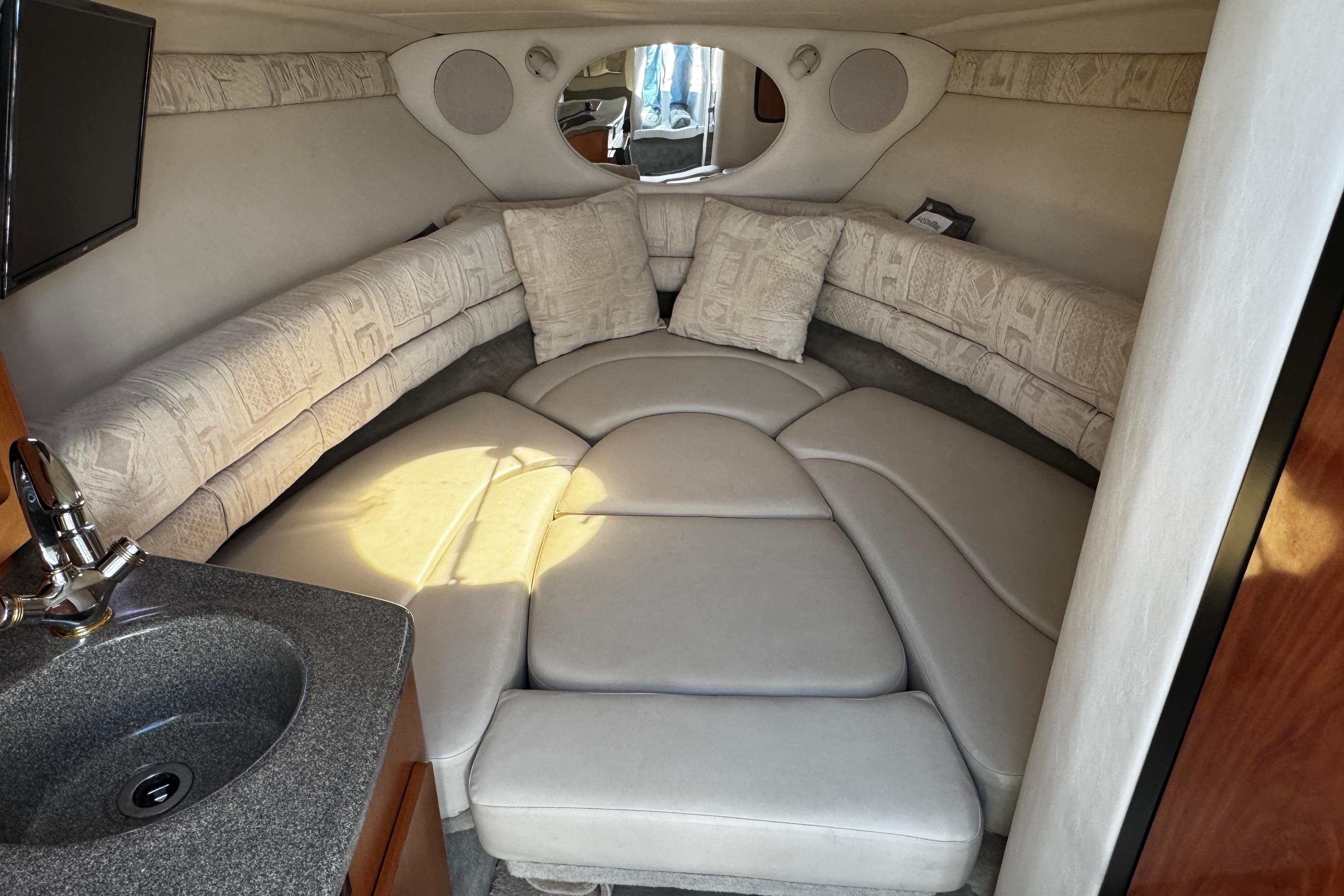 2004 Crownline 250 CR cabin interior with plush seating and compact sink area.