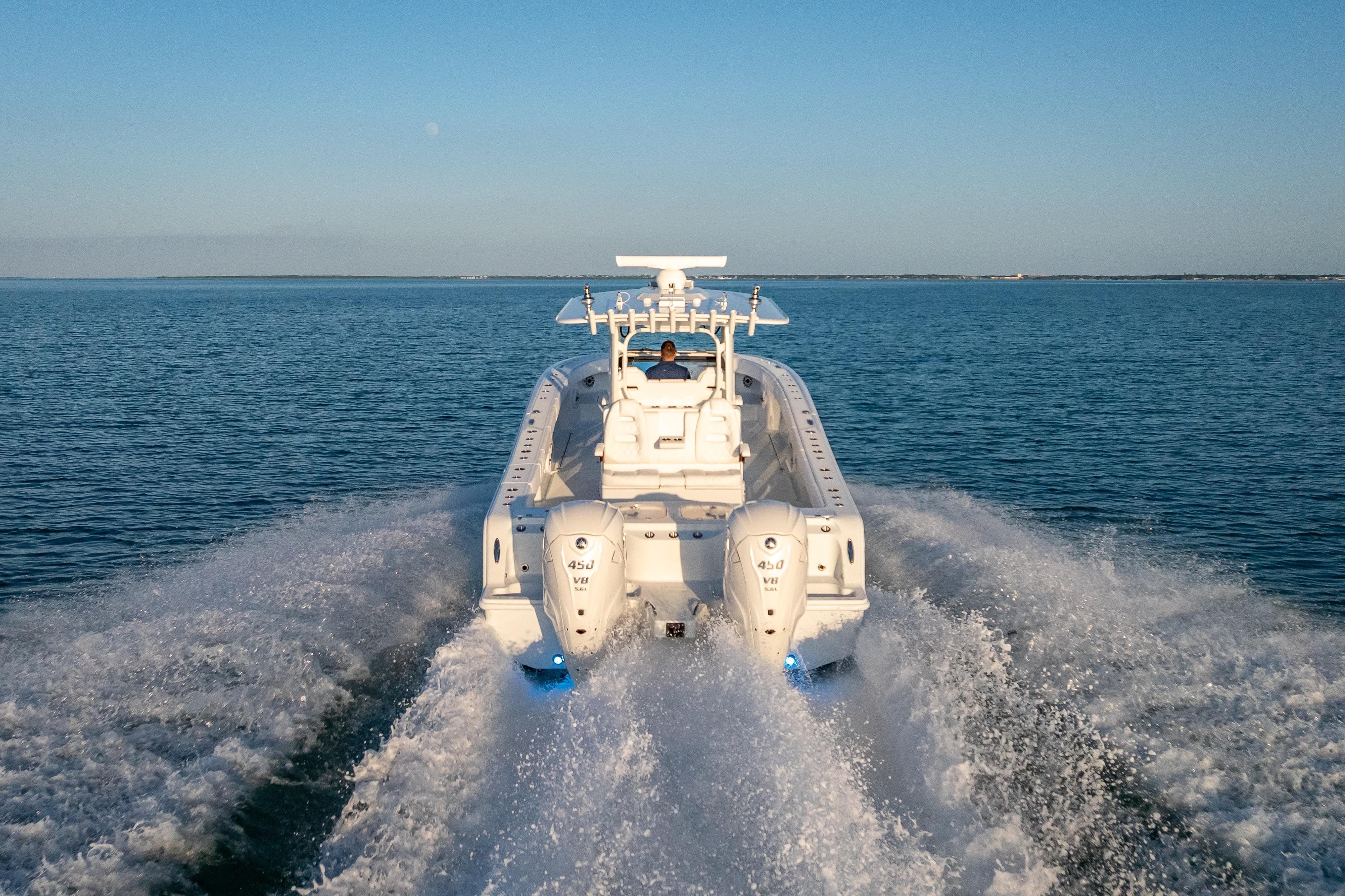 2026 Freeman 35 boat cruising on open water, rear view with twin engines.